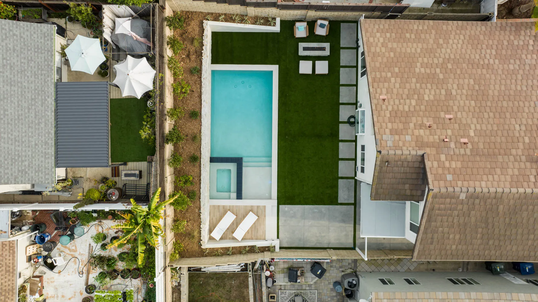 The property from high overhead, the pool and turf set behind the house.
