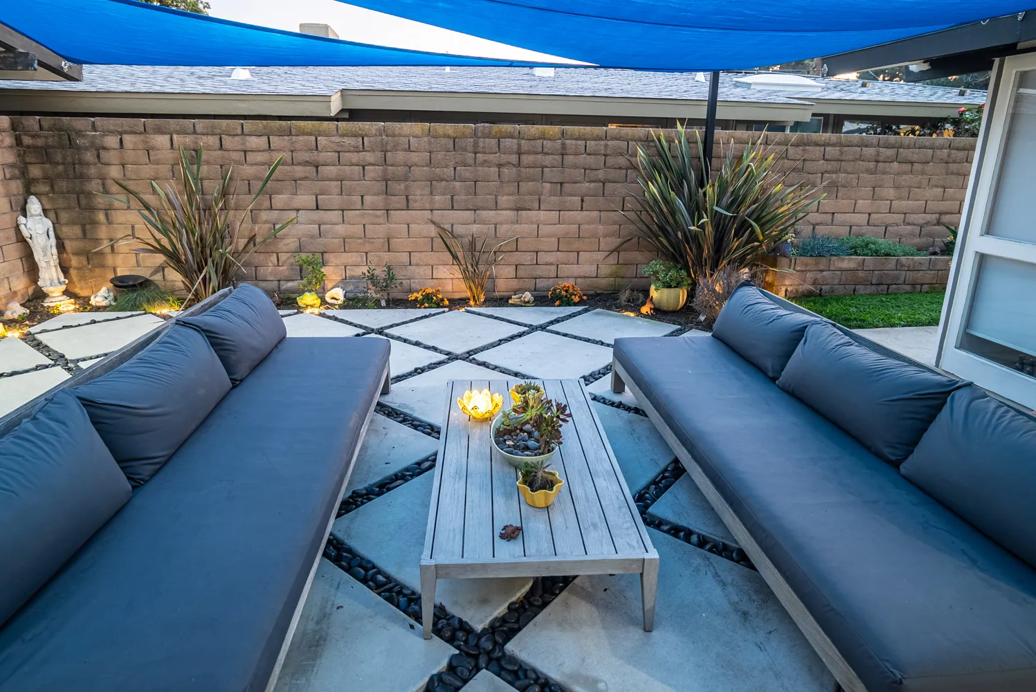 The lounge seating from above, candles on the table and planting lit along the wall.