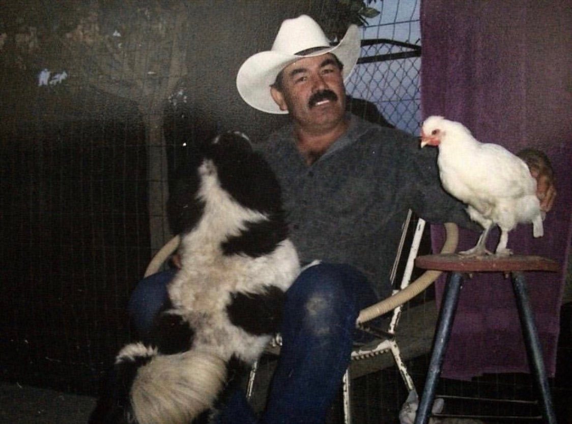 Isidro Perez Sr. with his dog and a chicken