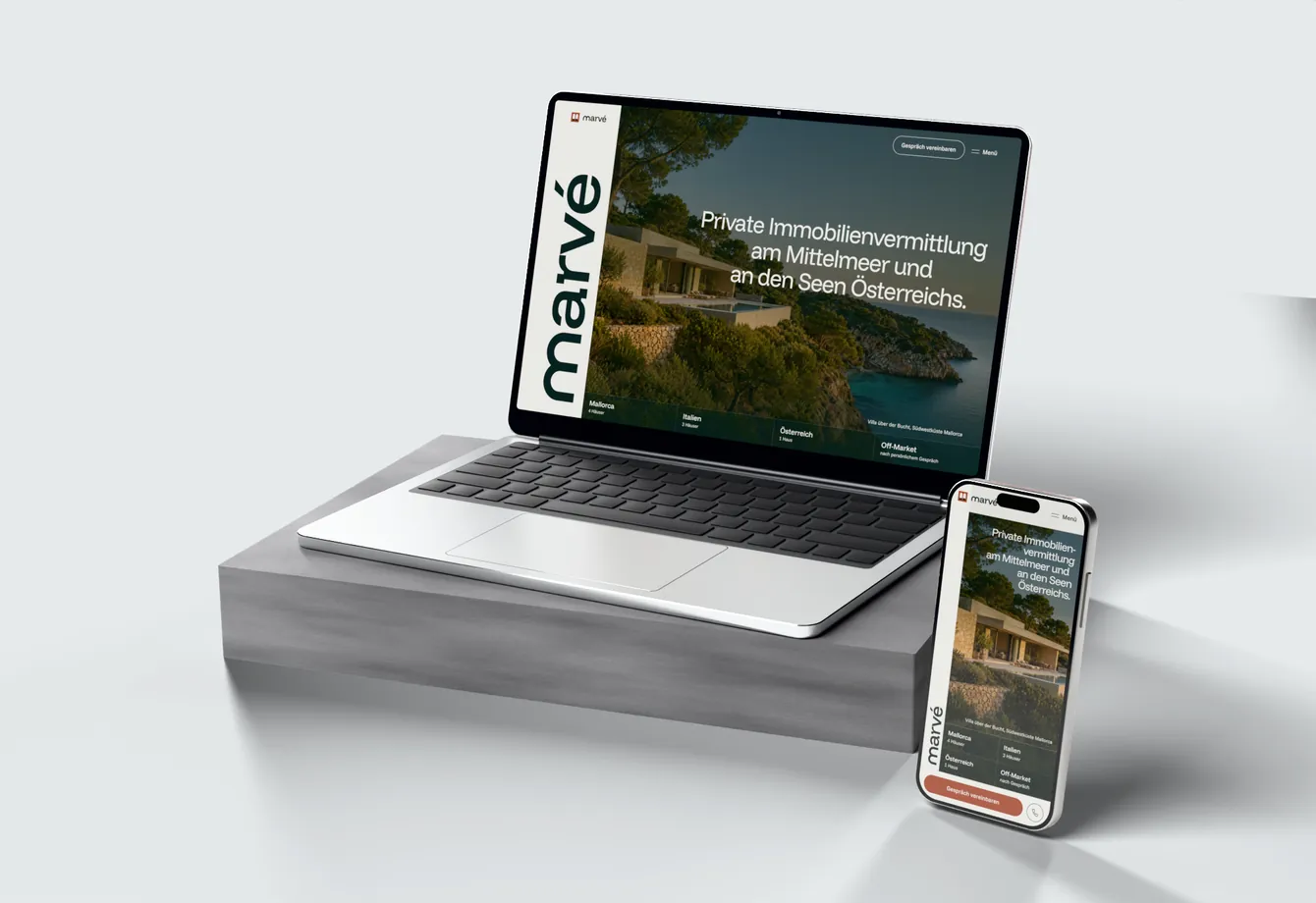 Die Website von Marvé auf einem Laptop und einem Handy: die Wortmarke senkrecht neben einem Haus über einer Bucht