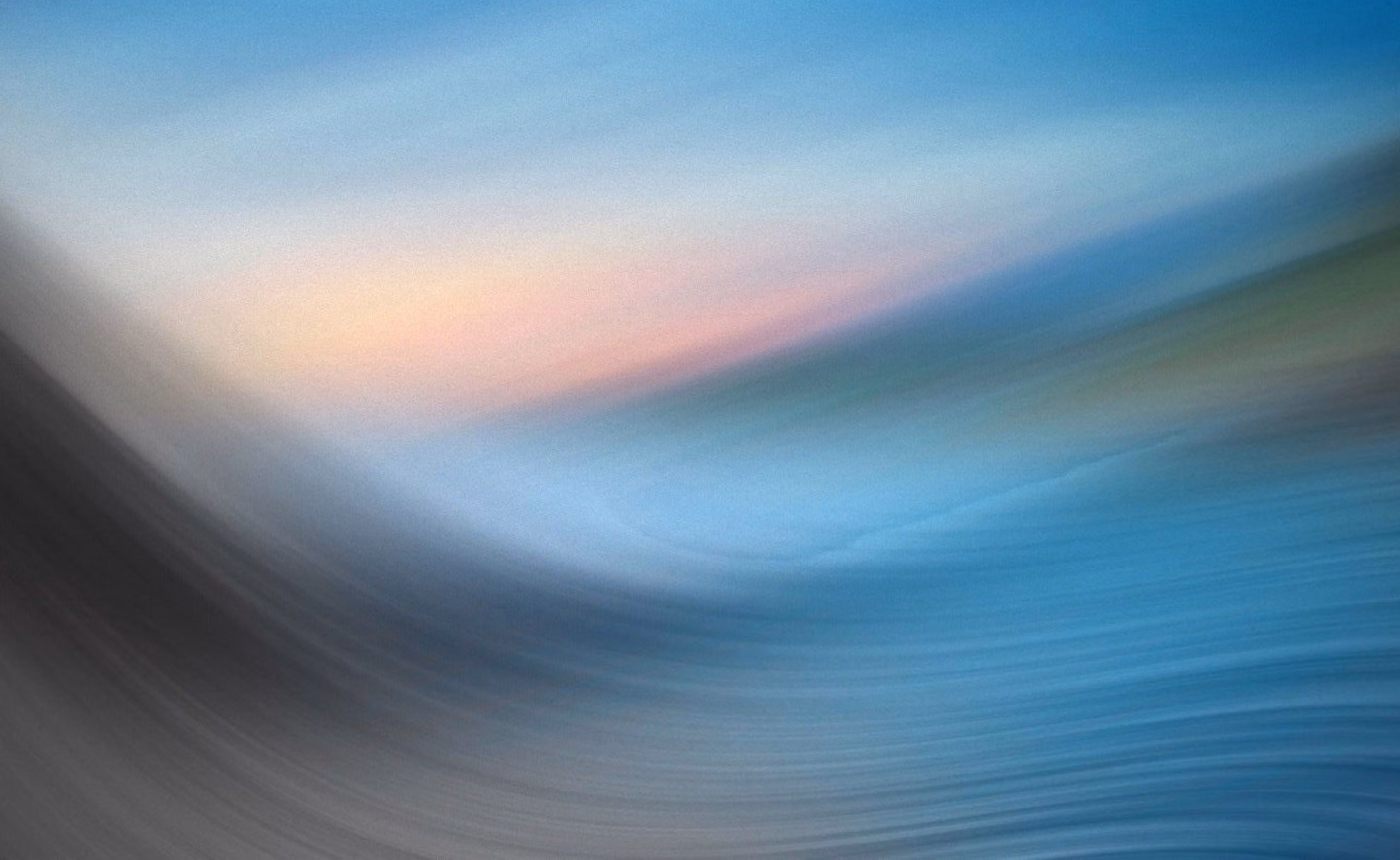 Image floue avec des teintes dégradées de bleu, rose, vert et noir formant des motifs abstraits.