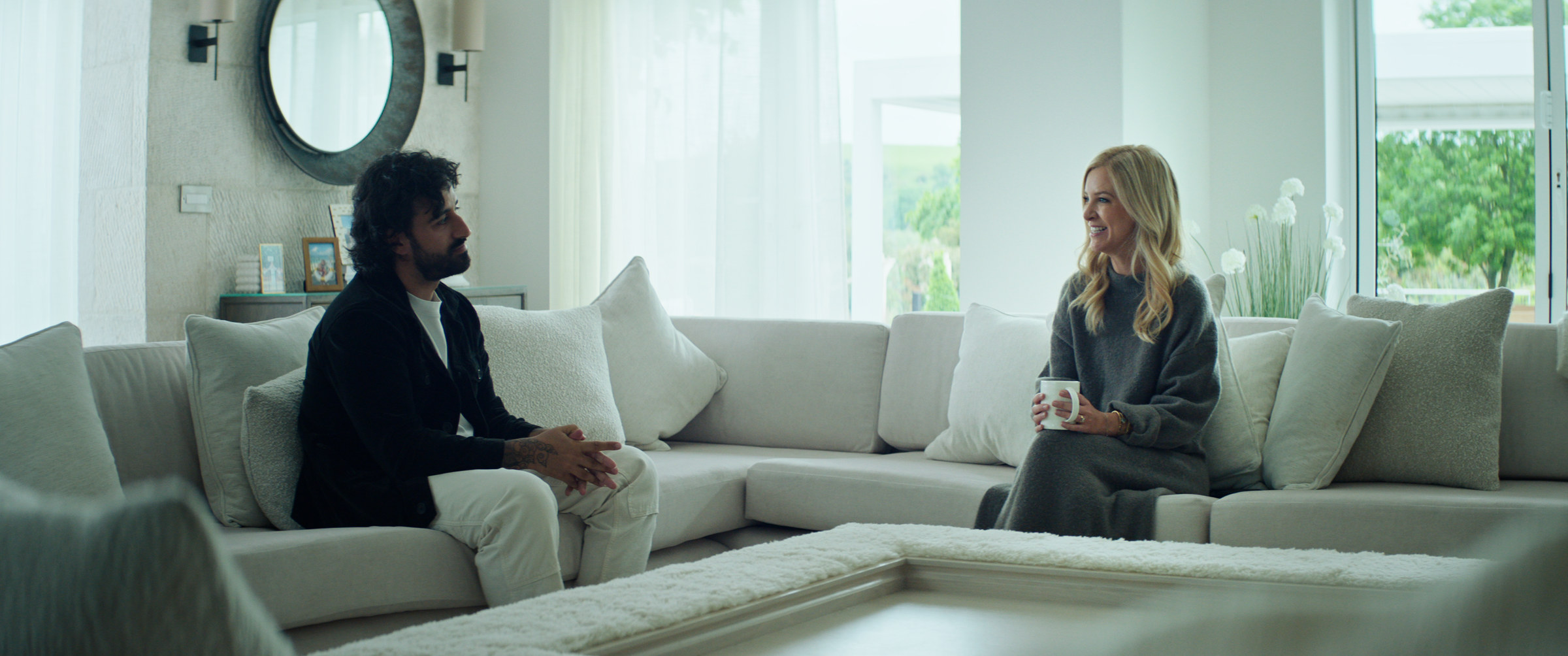 The Abnormal Beauty Company: a man and a woman talk on a white sofa in a bright living room