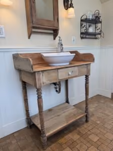 A farmhouse style vanity against a bathroom wall