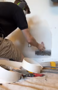 A handyman applying drywall mud