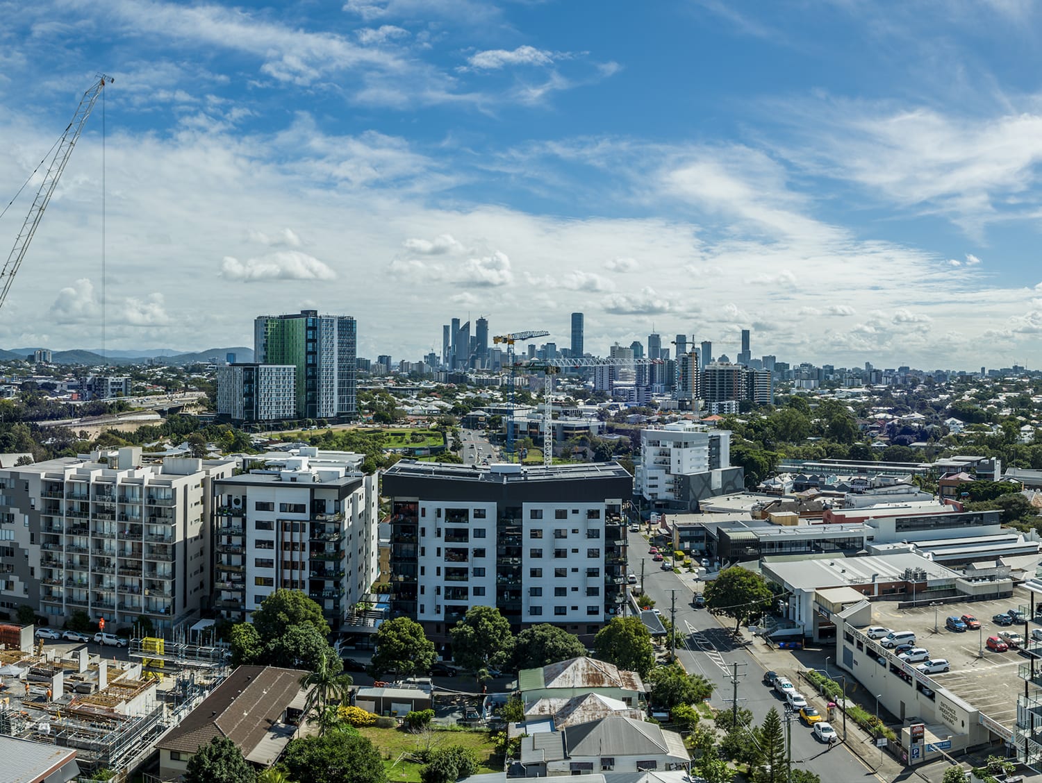 Aerial view over Brisbane's inner suburbs towards the CBD skyline