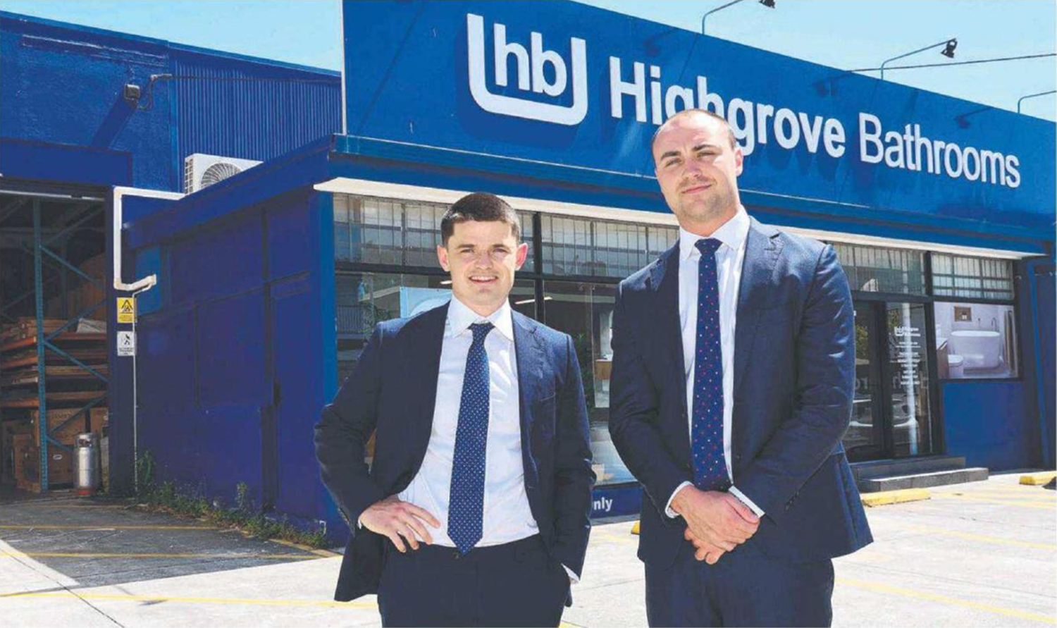 Two men in suits outside the Highgrove Bathrooms showroom at 899 Stanley Street, East Brisbane