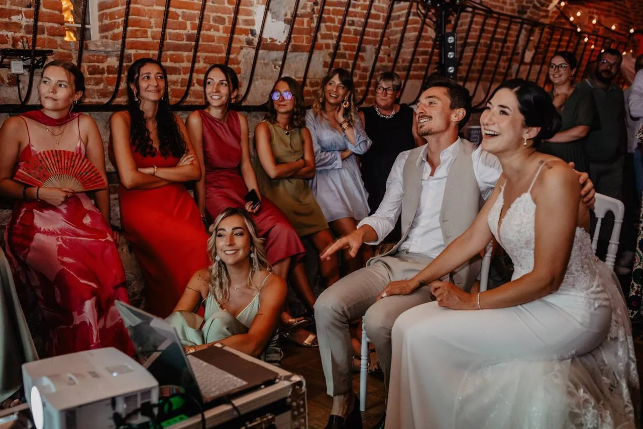 Invités riant devant une vidéo projection lors d'un mariage animé par DJ Gus