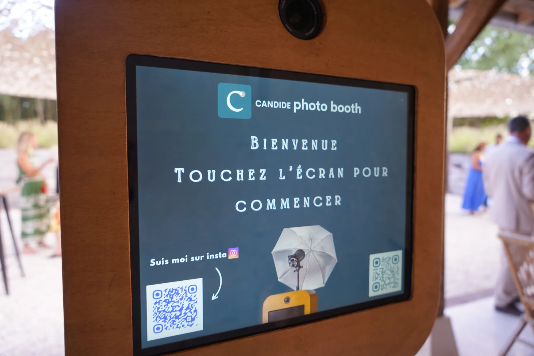 Photobooth vintage installé dans une décoration de mariage romantique avec voilages et origamis