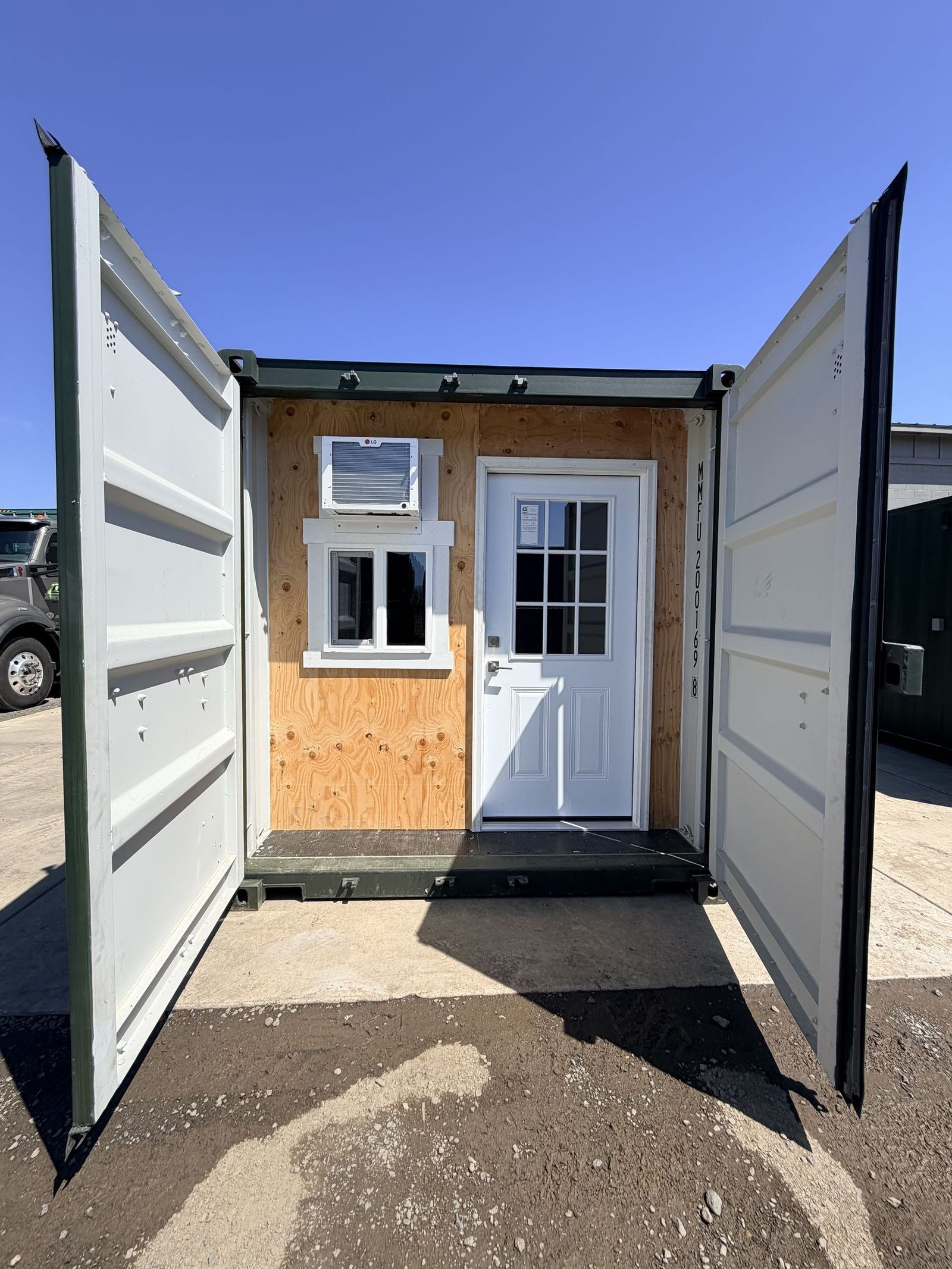 Twenty foot container office with both cargo doors open, showing a personnel door, window, and air conditioner