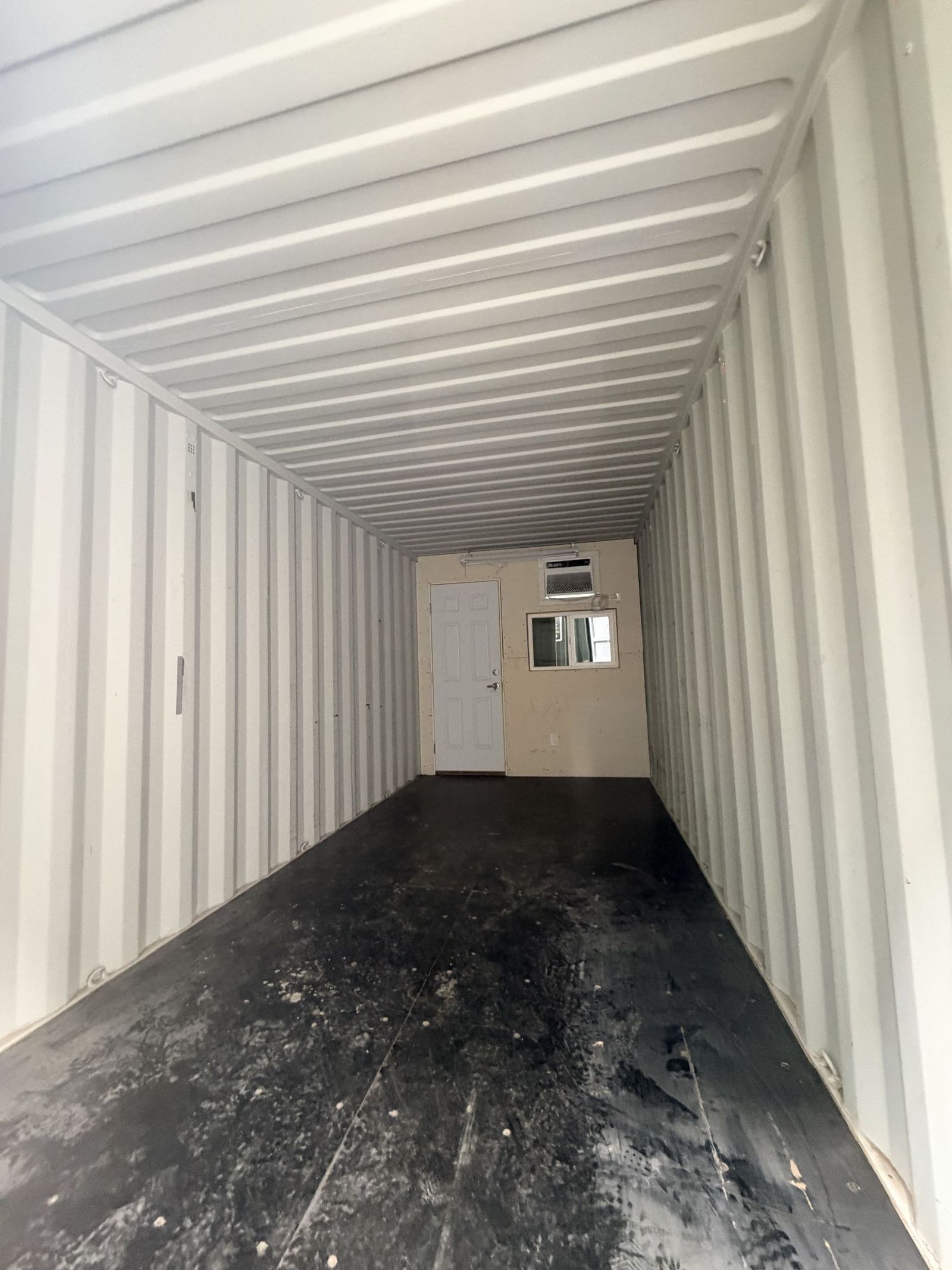Twenty foot semi office container with an enclosed office at the far end and open storage in front