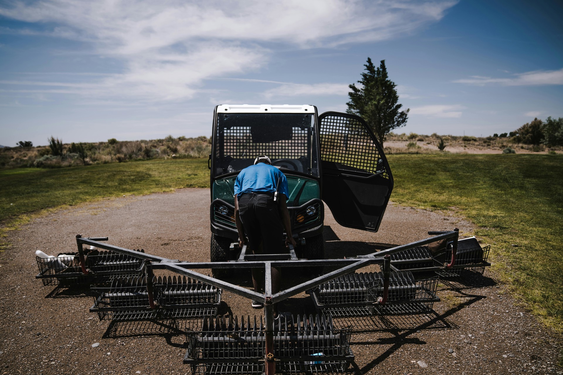 Worker beside a farm vehicle and agricultural equipment