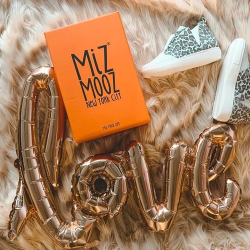 A Miz Mooz shoe box beside leopard print sneakers