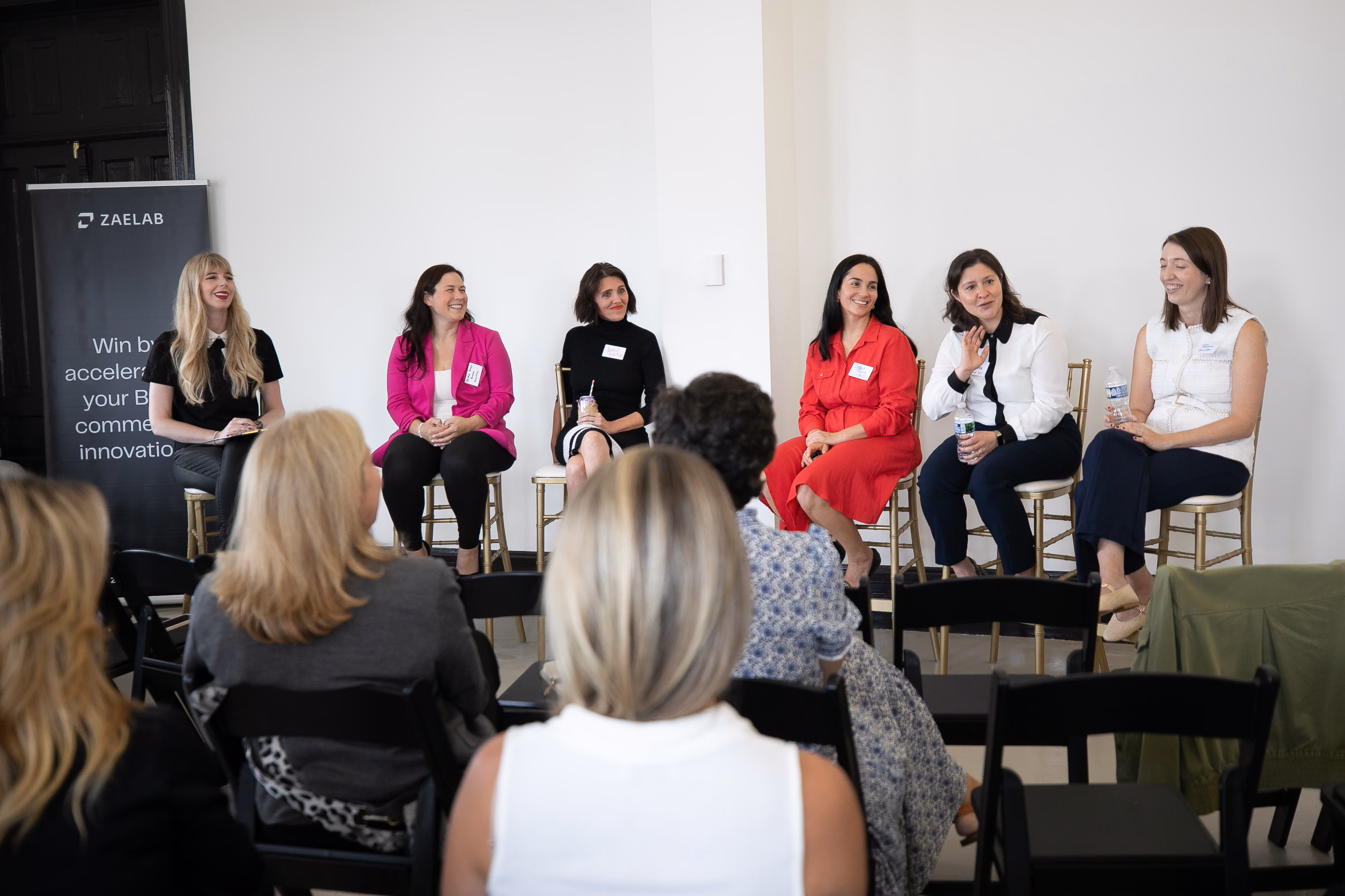 Panel 2 speakers with a moderator smiling and speaking at the Women in B2B: Though Leadership Collective Event hosted by Zaelab in Chicago