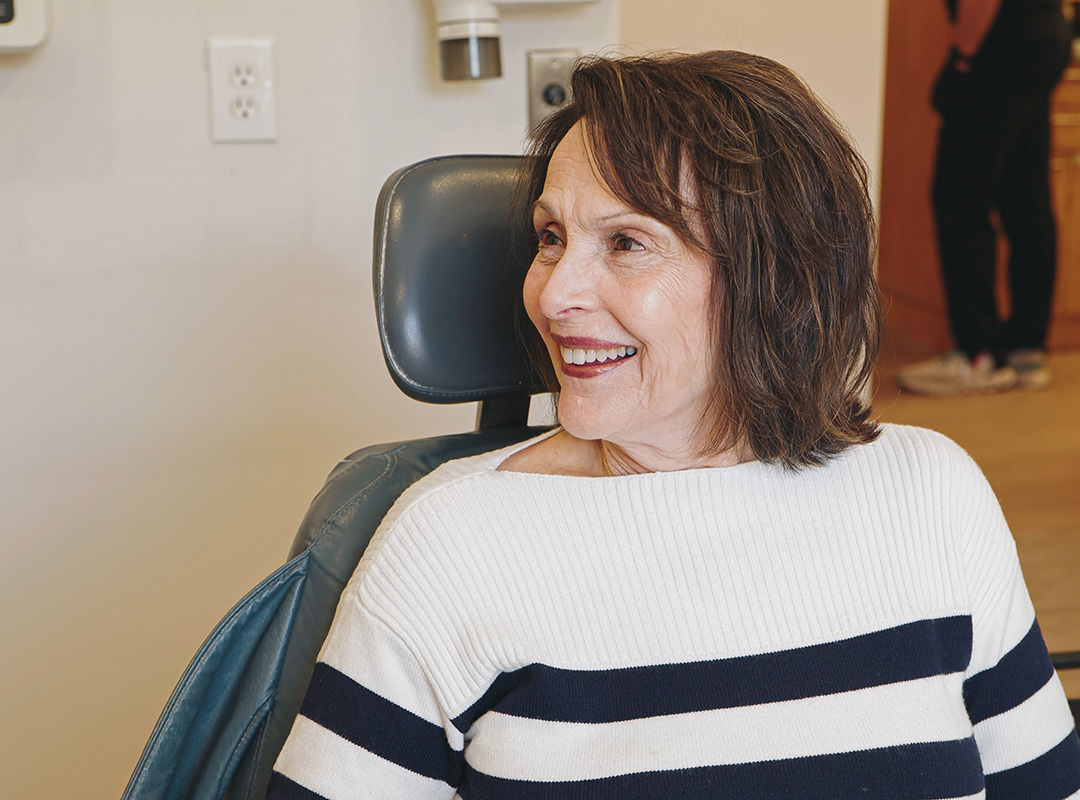 Smiling patient seated comfortably in a treatment room at Schaefer Dental Group in Brighton, MI.