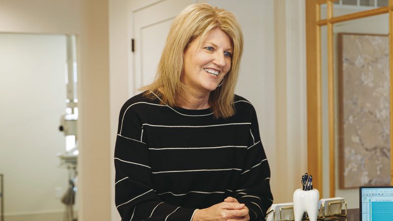 Schaefer Dental Group team member welcoming a patient at the front desk in the Brighton, MI dental office.