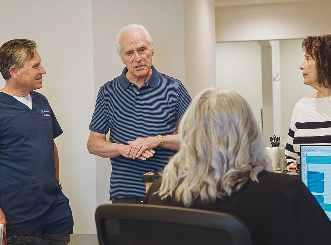 Schaefer Dental Group dentist speaking with patients and team members at the dental office in Brighton, MI.