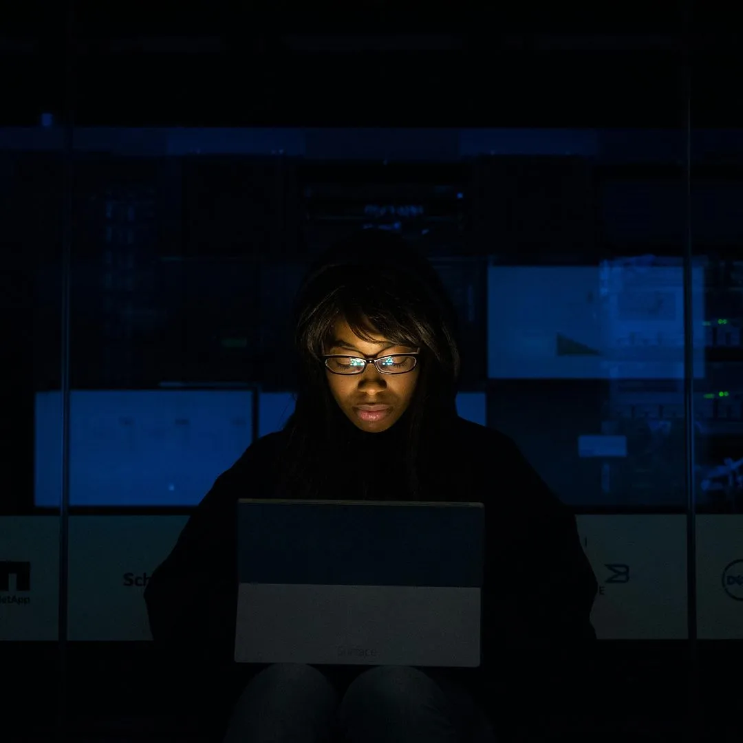 Engineer working by screen light in a dark room