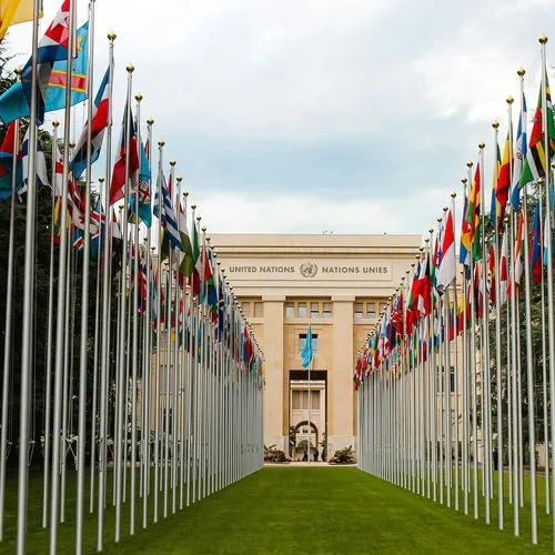 Rows of national flags lining a walkway leading to the United Nations building
