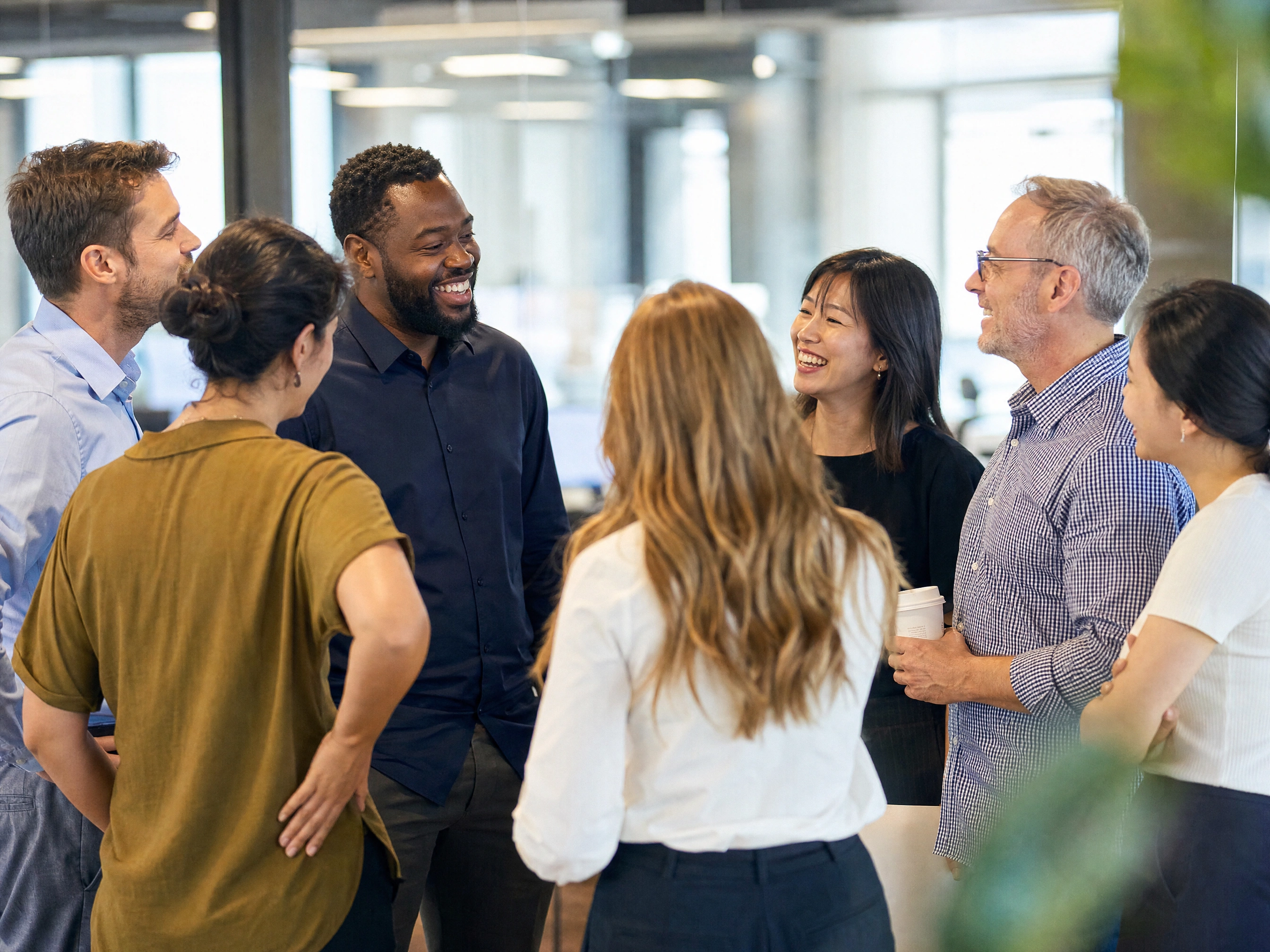 A diverse group of coworkers of different ages and backgrounds talking in an office