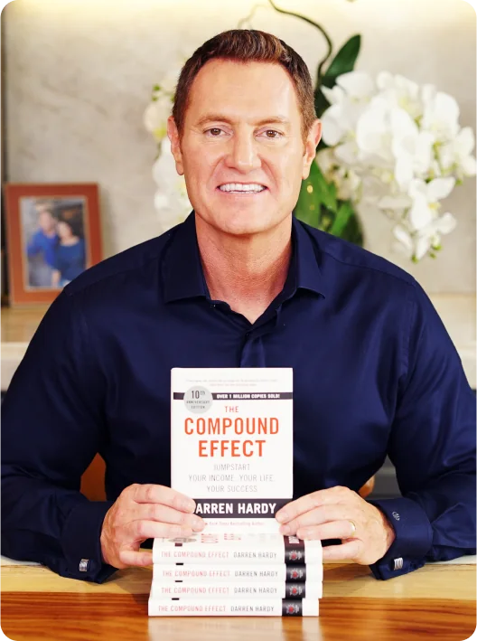 Darren Hardy with a stack of The Compound Effect