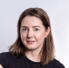 Headshot of Paula, smiling in a black top