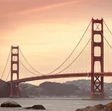 Golden Gate Bridge at sunset, seen from a rocky shoreline