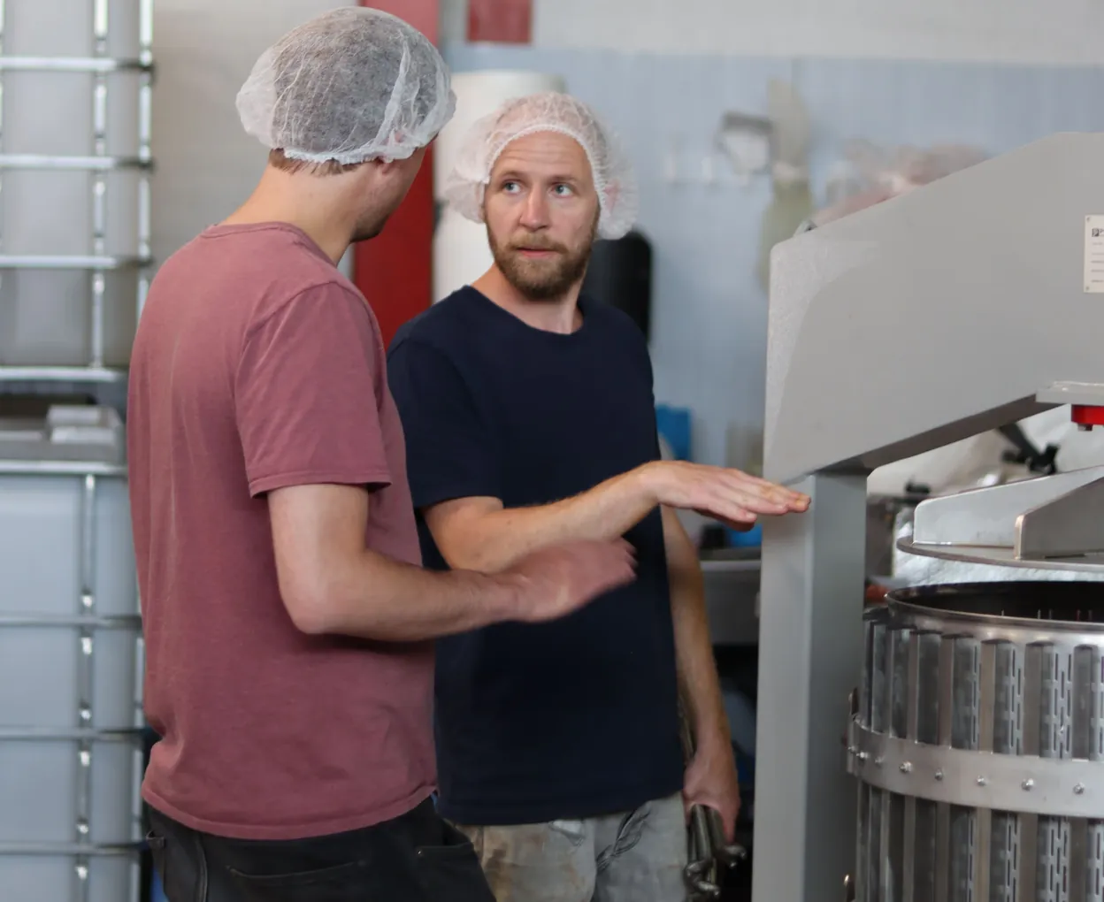 Twee collega's met haarnetjes aan de machine