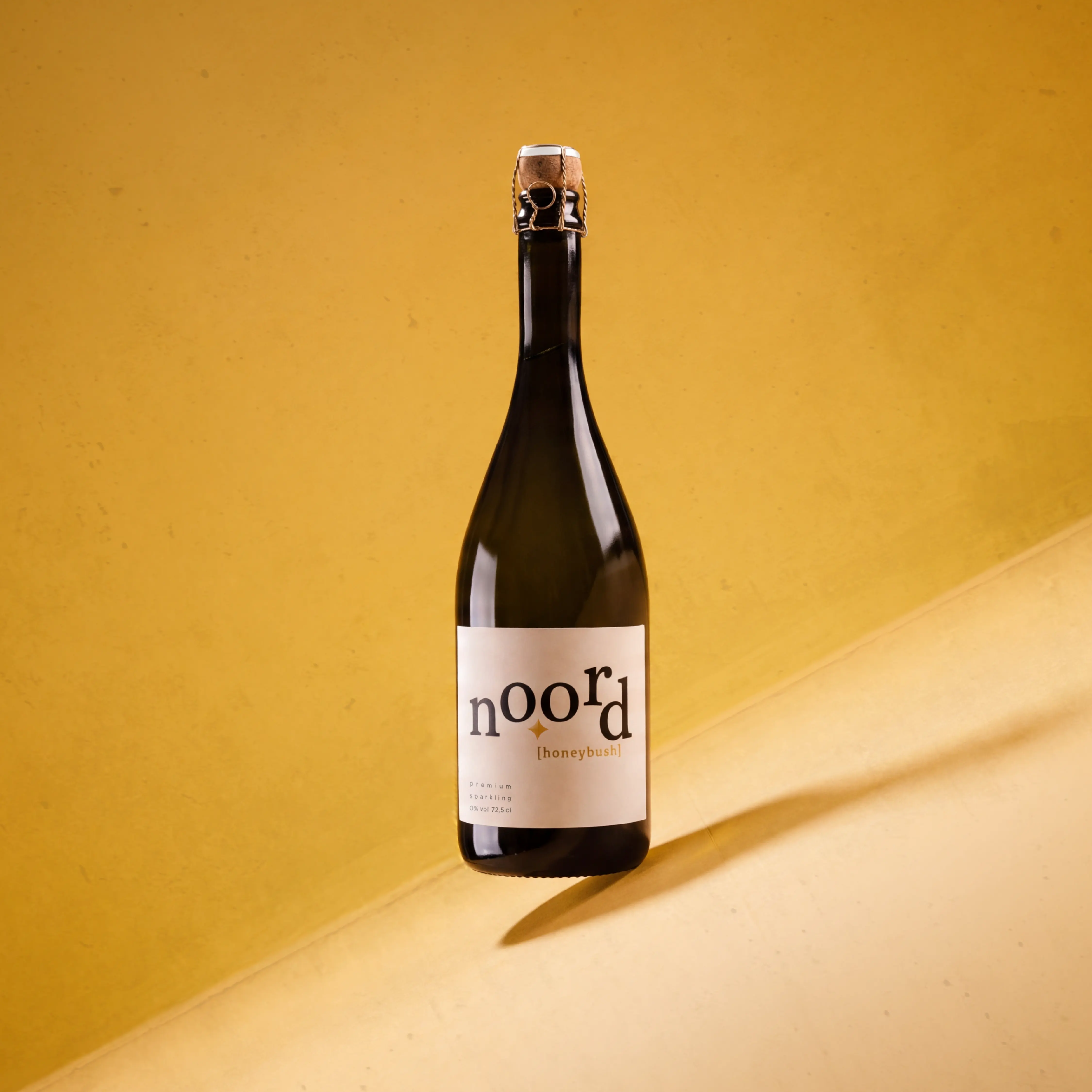 Fles NO.ORD Honeybush tegen een okergele achtergrond