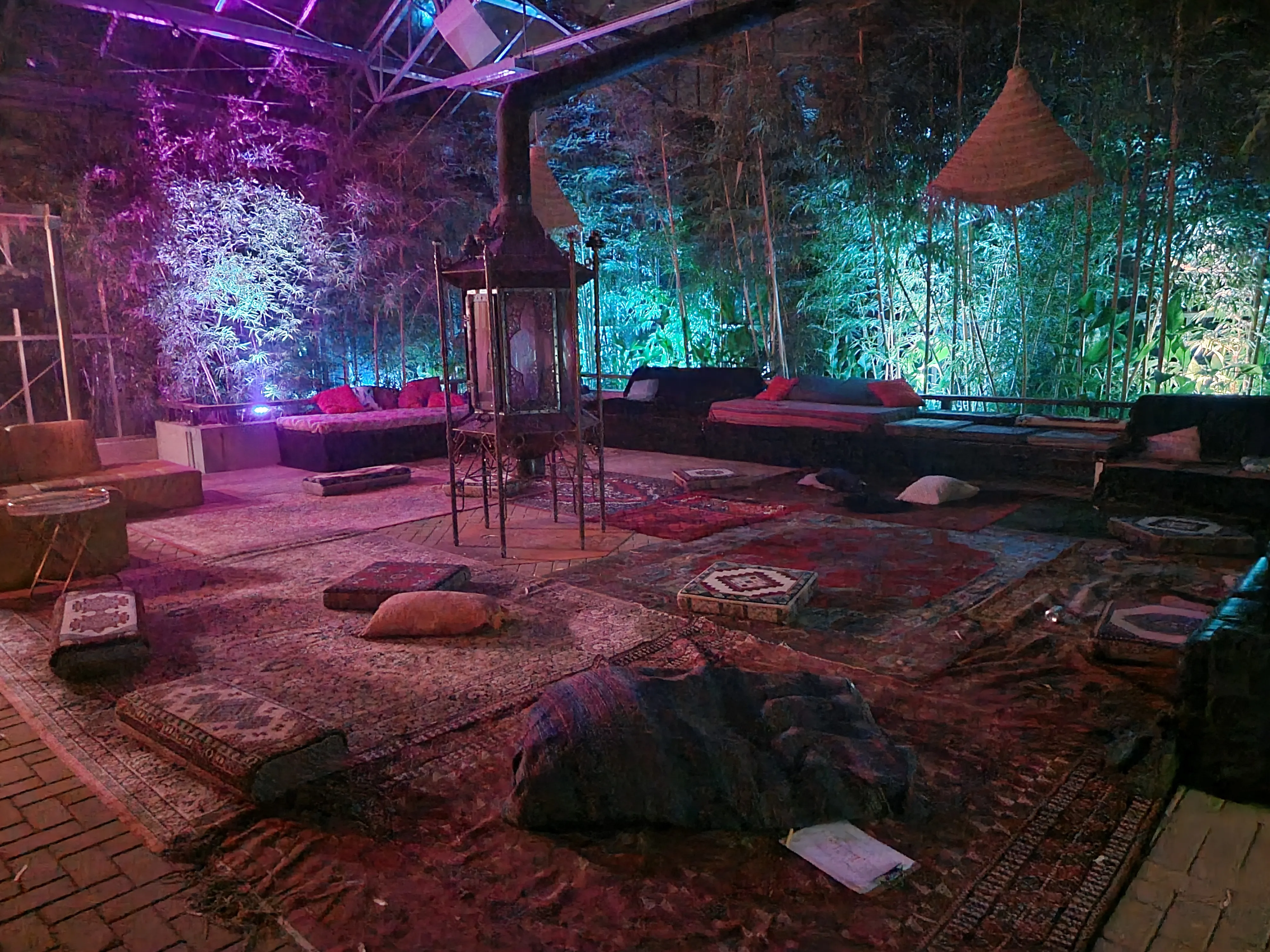 Chill-out plek met tapijten, kussens en gekleurd licht op een festival