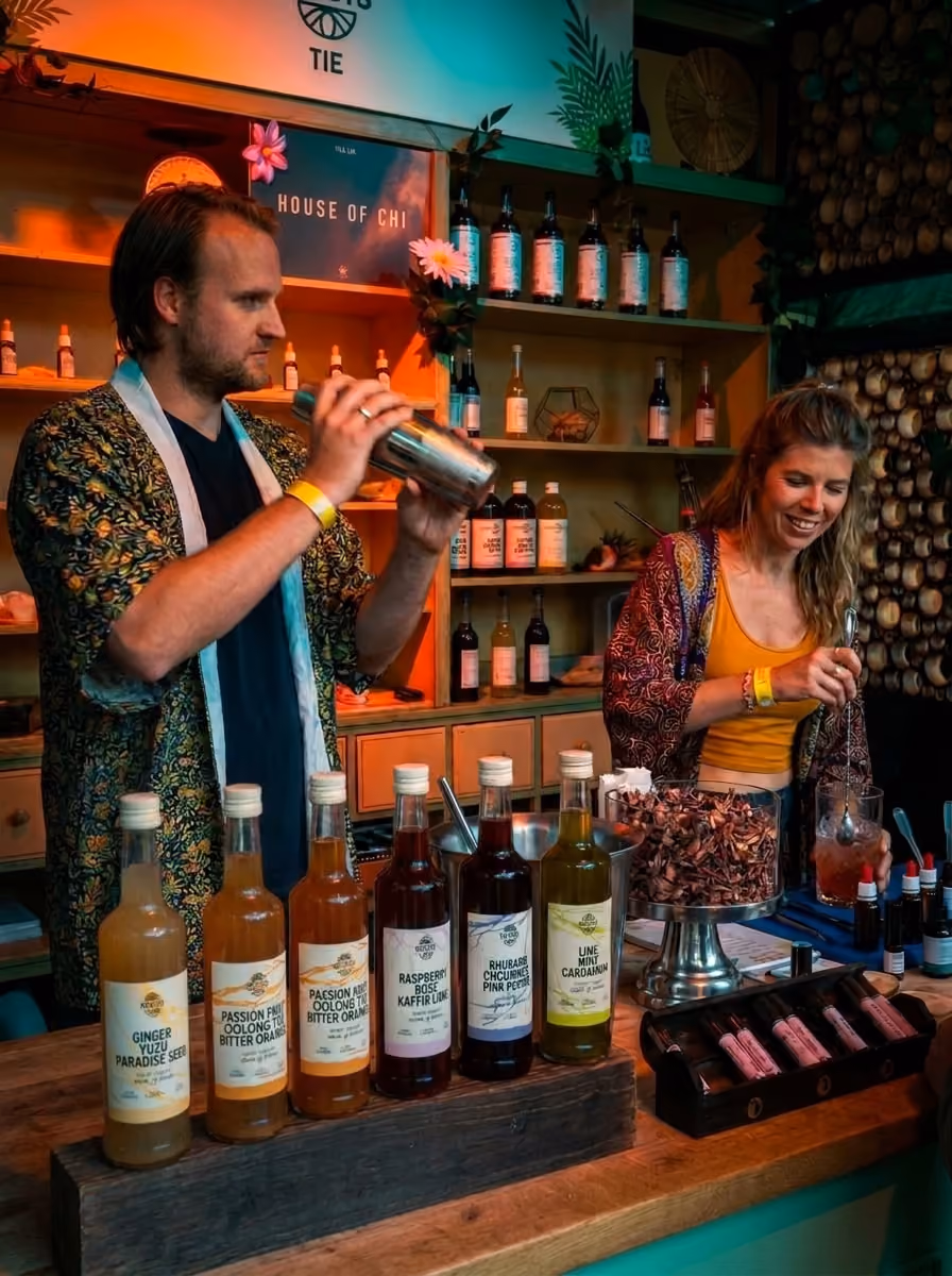 Twee bartenders maken drankjes achter de botanical bar van House of Chi