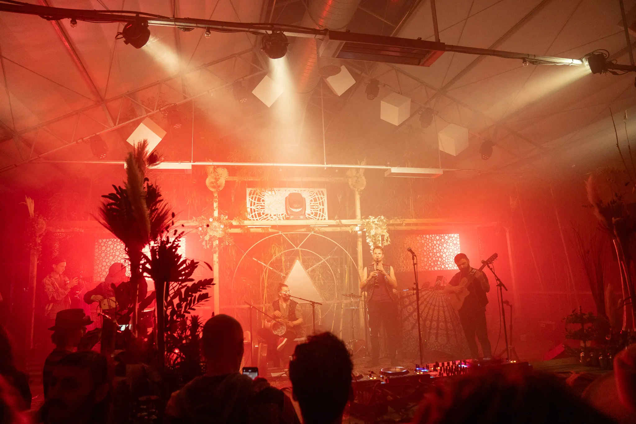 Optreden op een podium in rood licht voor een festivalpubliek