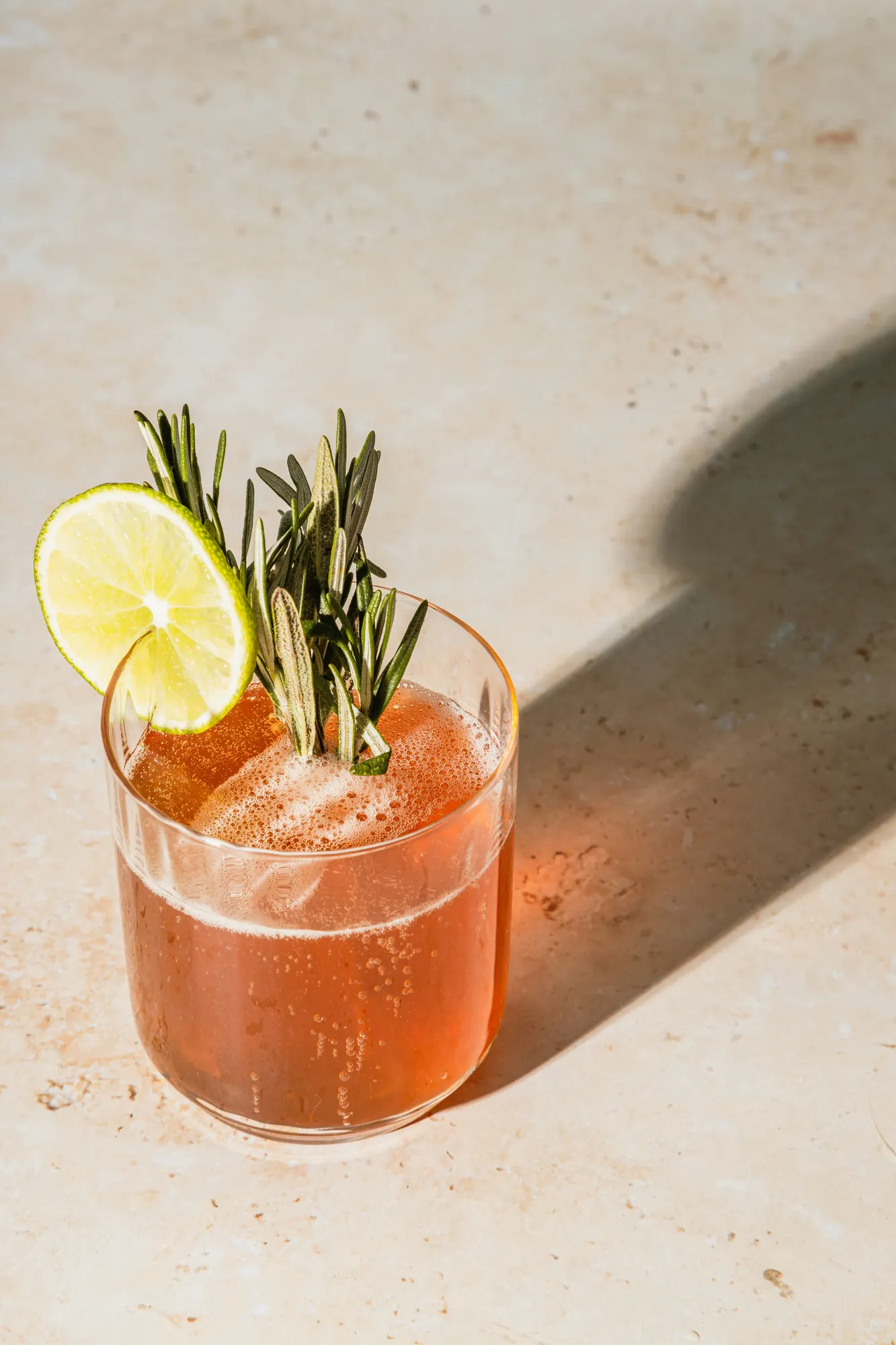 Alcoholvrije cocktail met limoen en rozemarijn in een glas