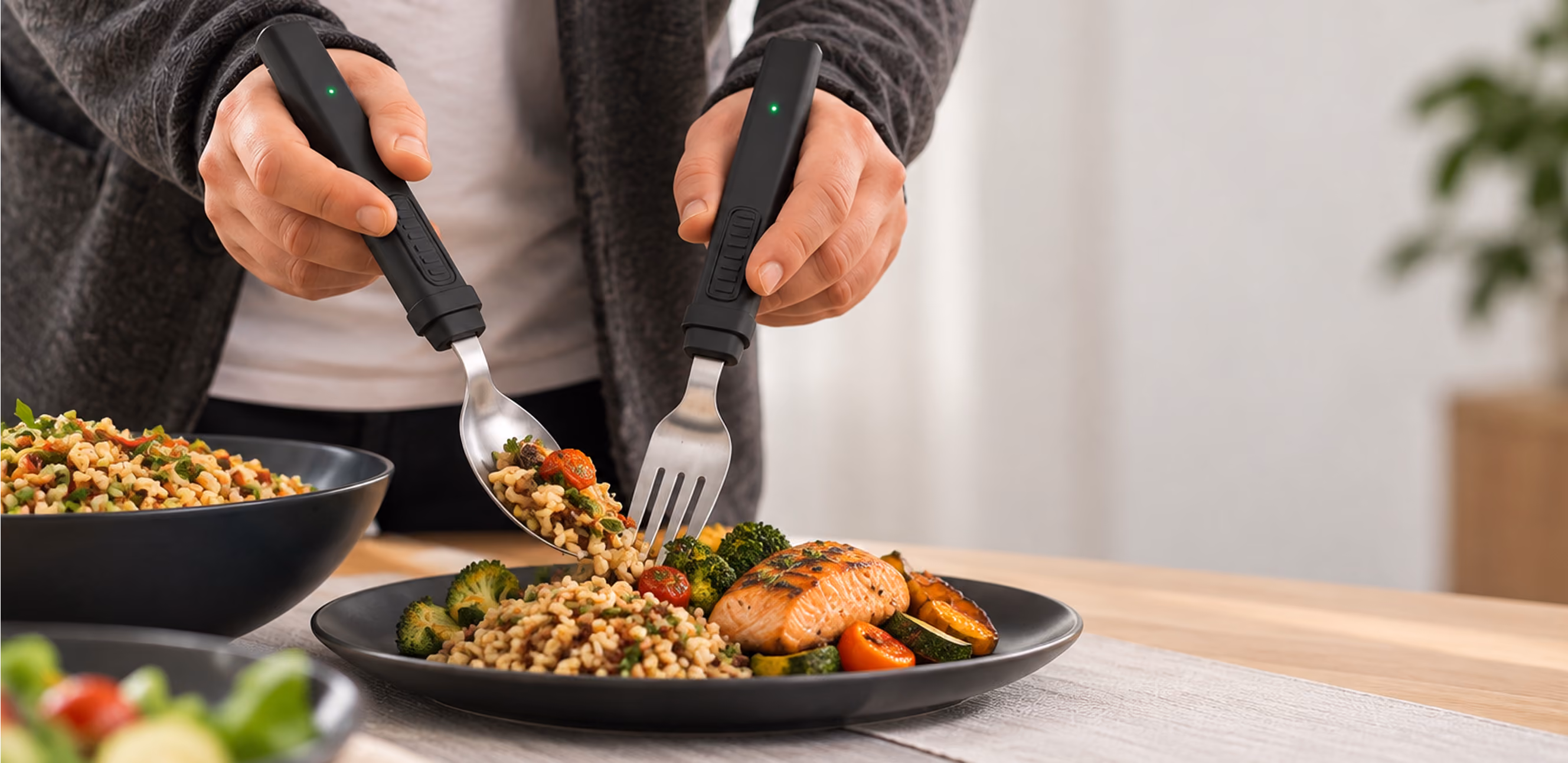 Two hands using a BiteQ fork and spoon over a plate of food