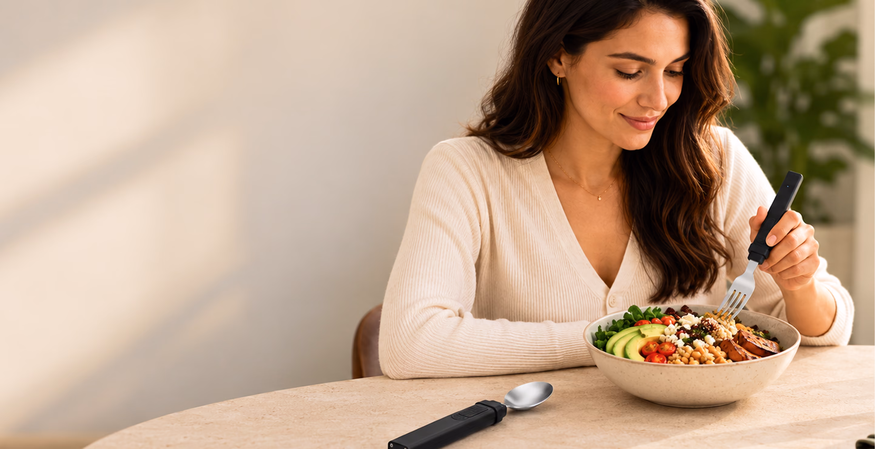 Woman eating a grain bowl with the BiteQ Smart Utensil fork