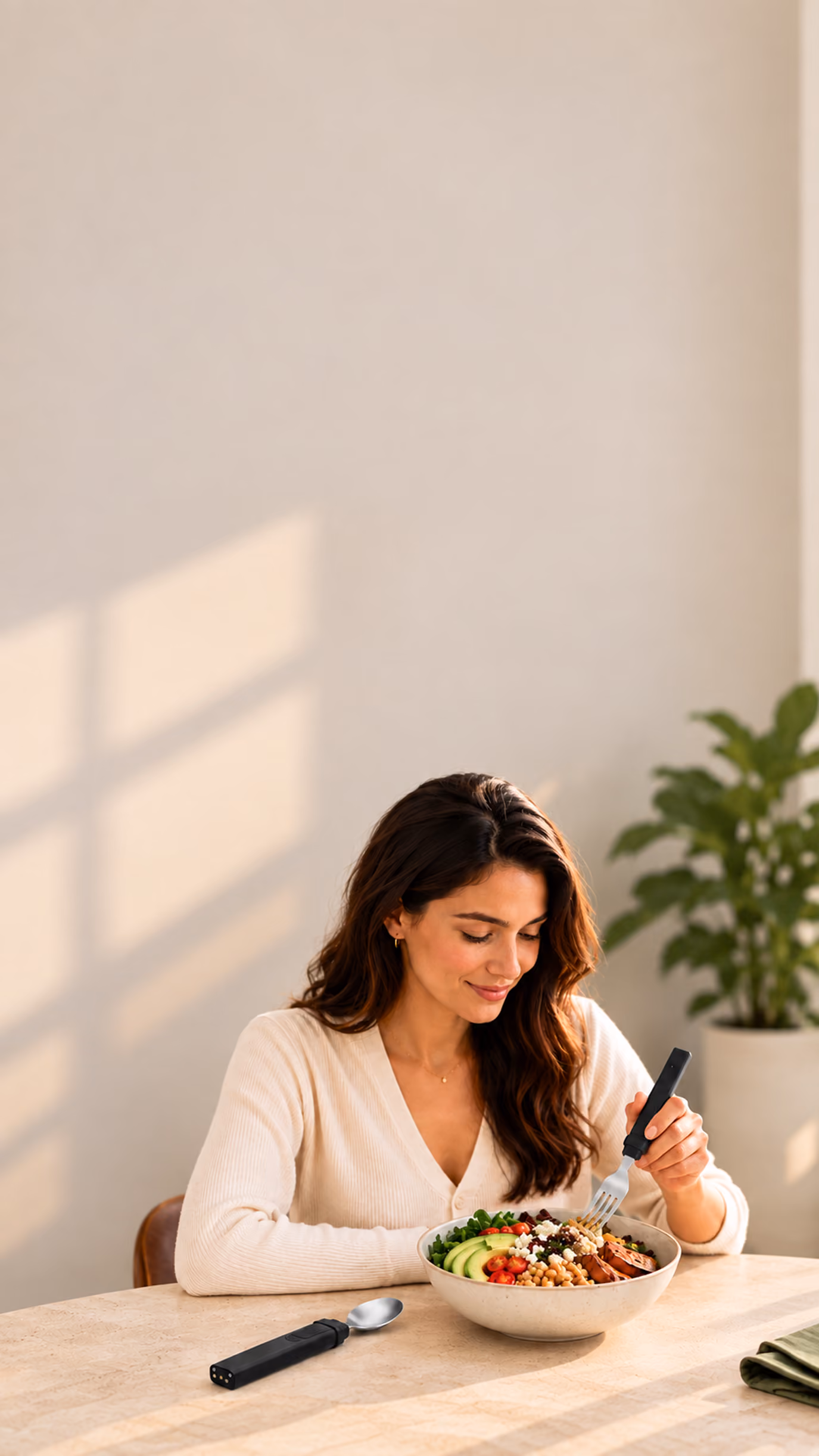 Woman eating a grain bowl with the BiteQ Smart Utensil fork