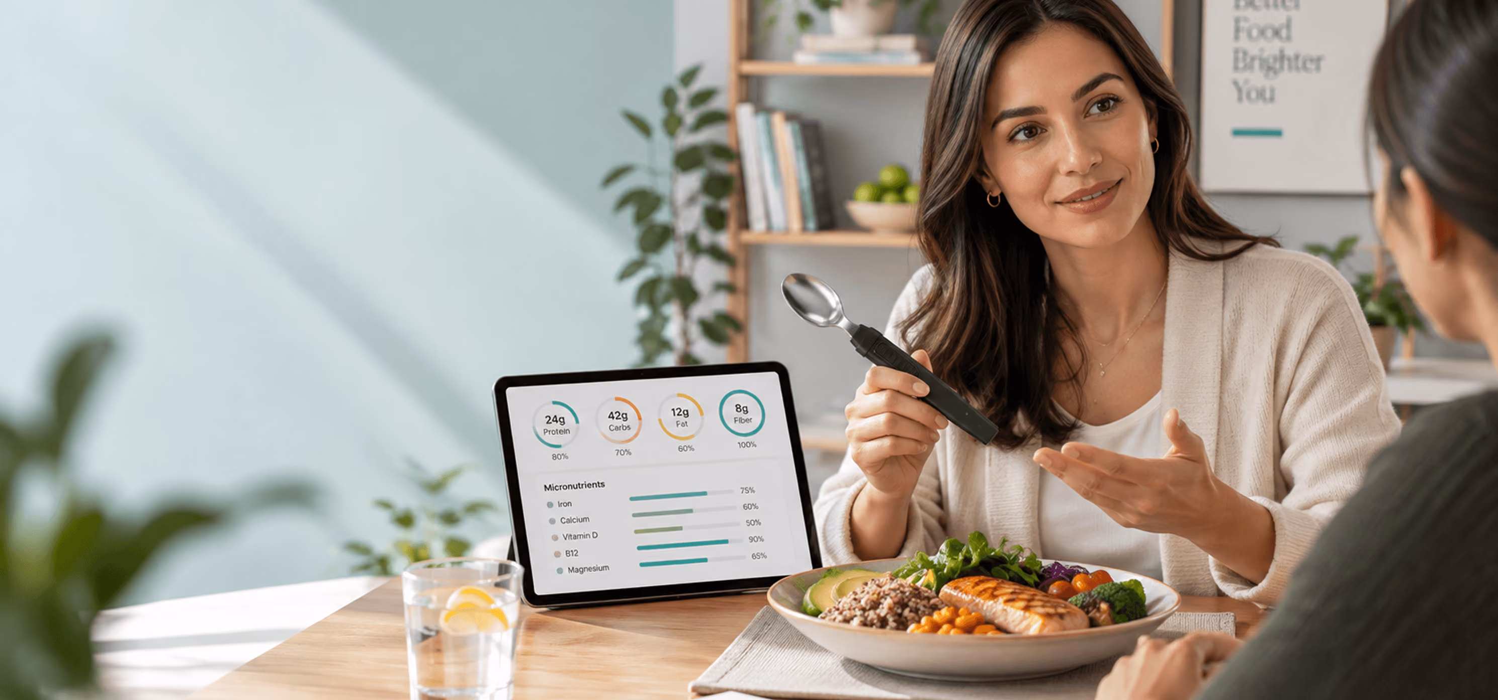 Dietitian holding the BiteQ smart spoon beside a tablet showing nutrient data