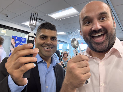 Two members of the BiteQ team smiling and holding up a BiteQ prototype