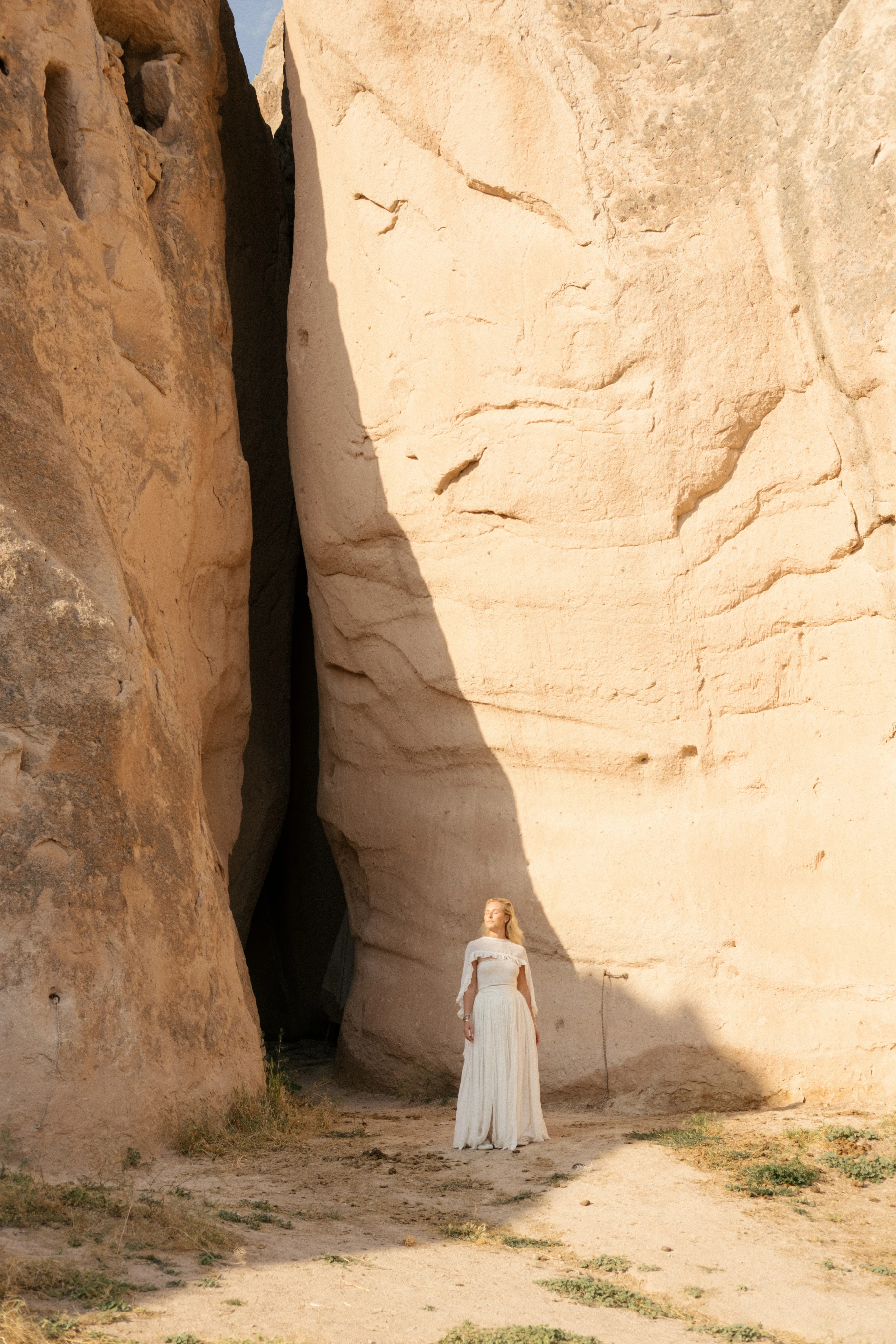 Cecilie in a white dress among pale rock formations
