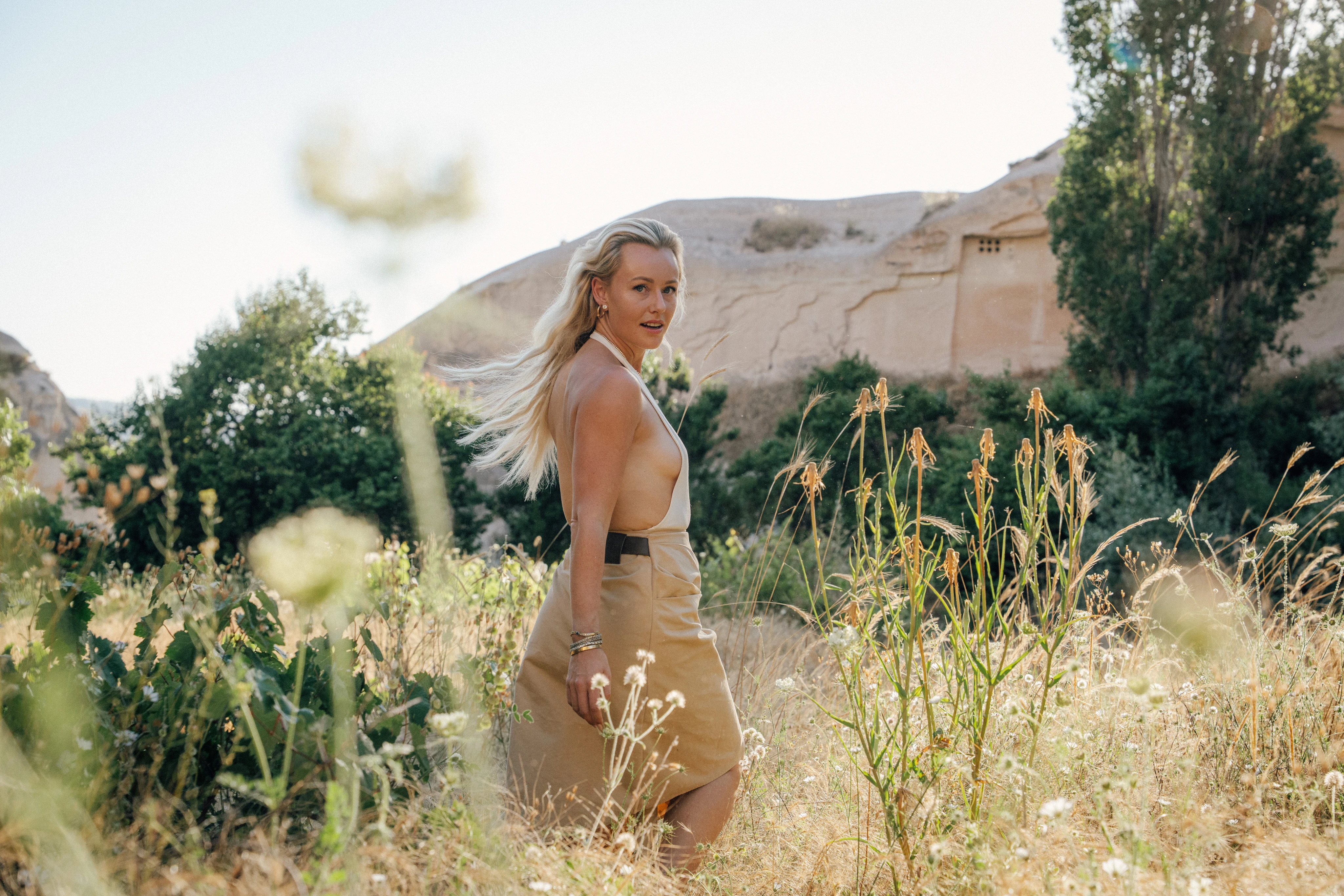 Cecilie standing in a sunlit landscape