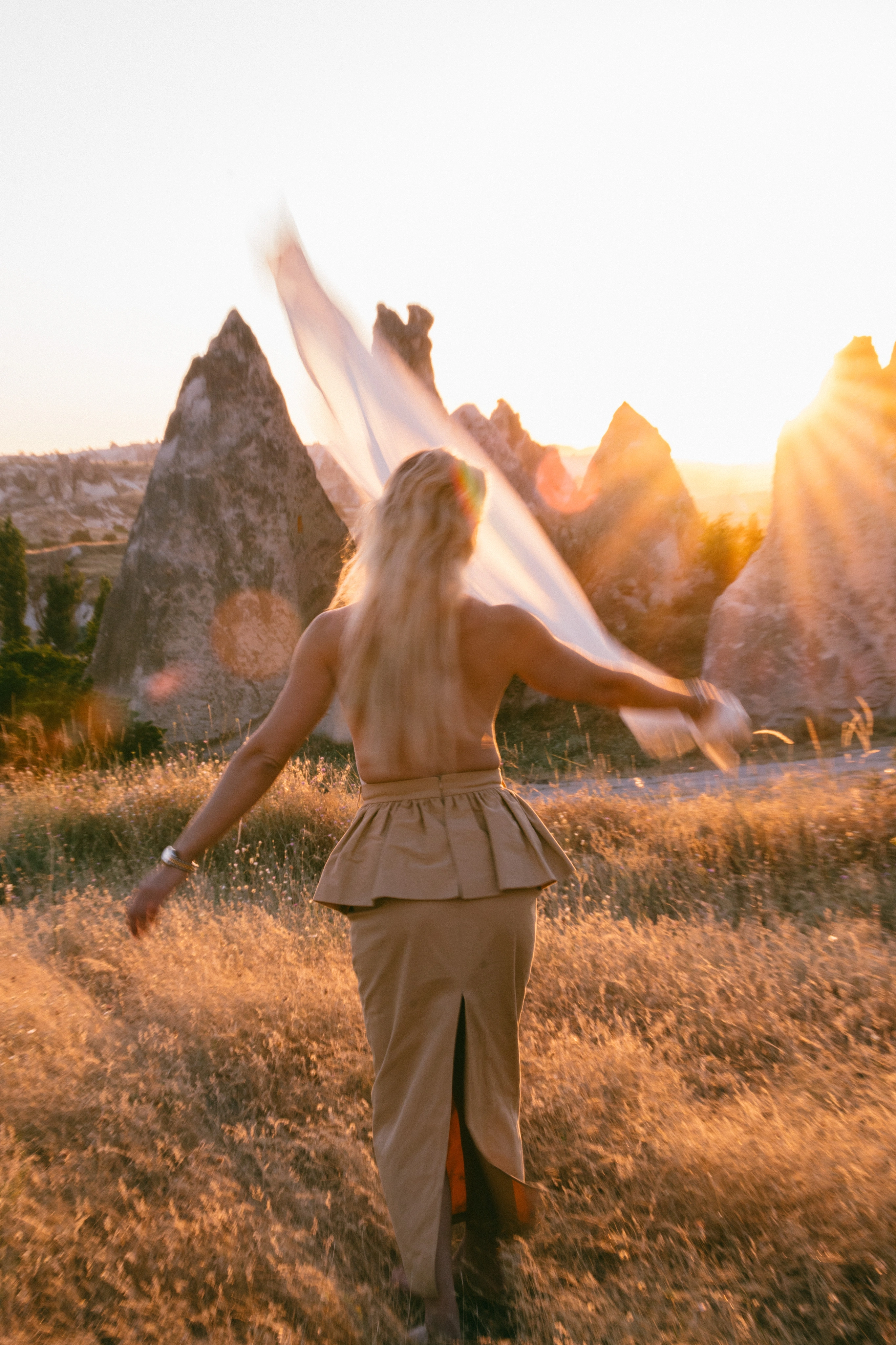 Cecilie in a white dress among pale rock formations