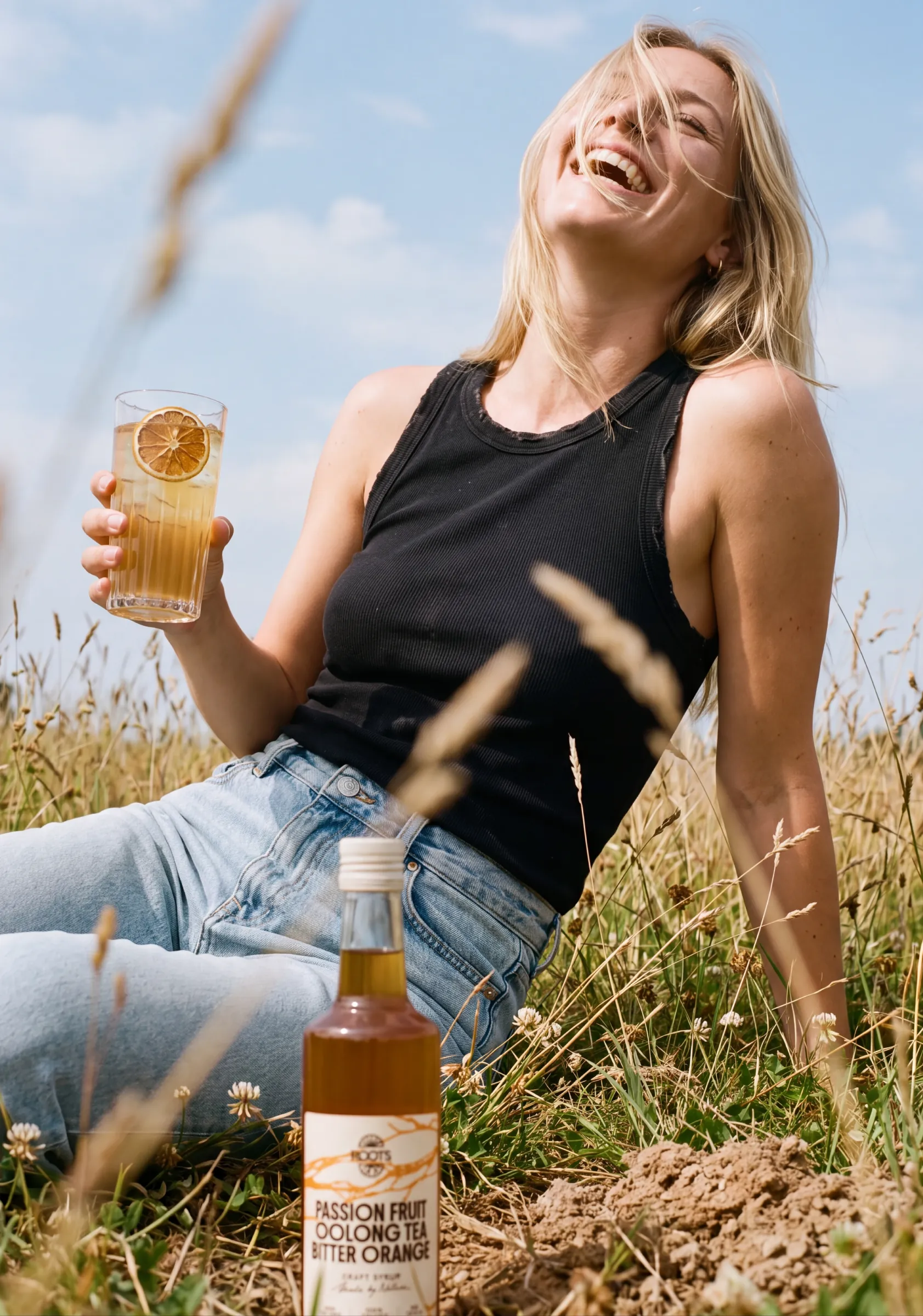 Vrouw drinkt Roots buiten in het gras