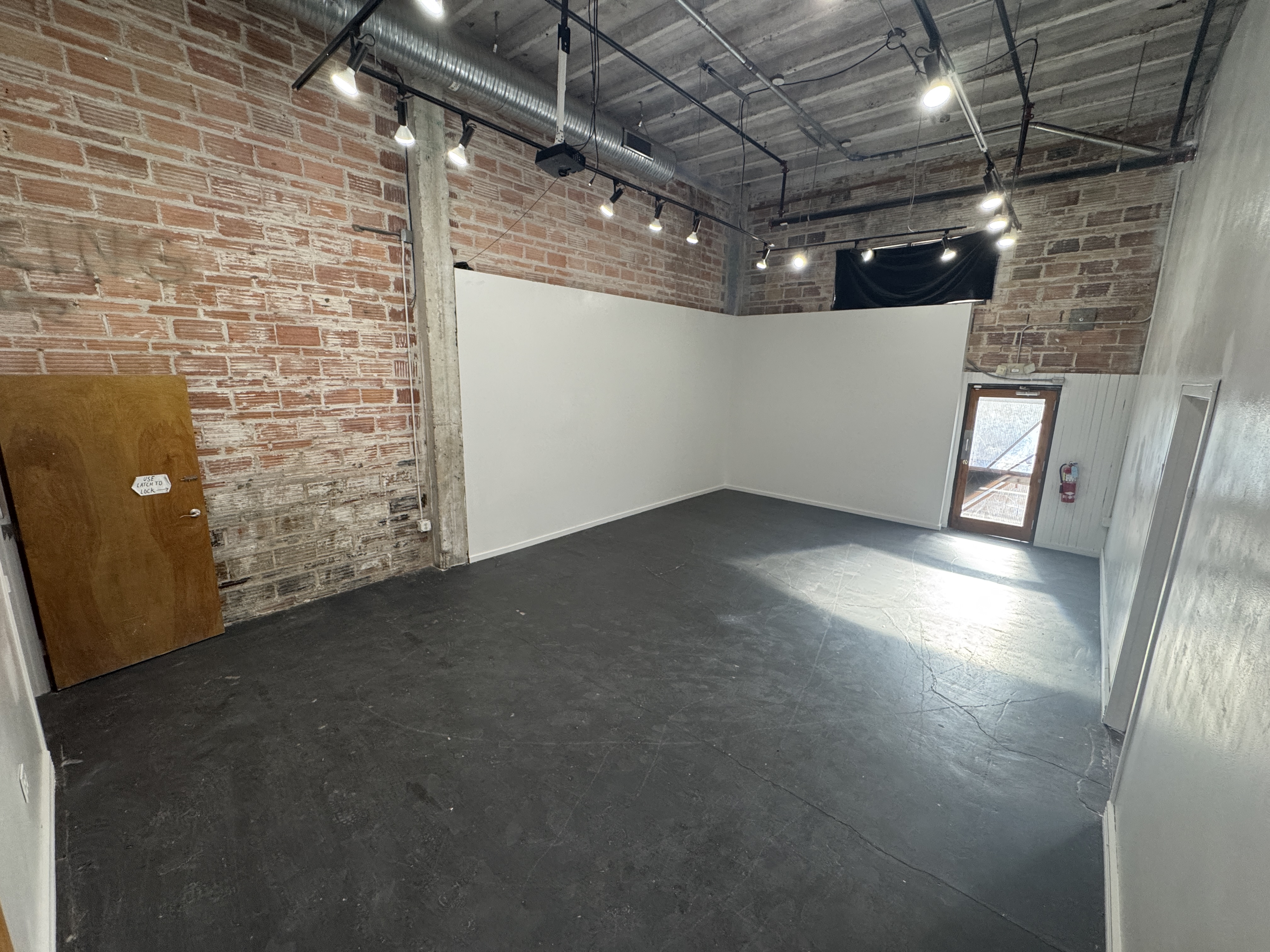 The empty main hall at 108 Blue Star, with the wooden load-in door