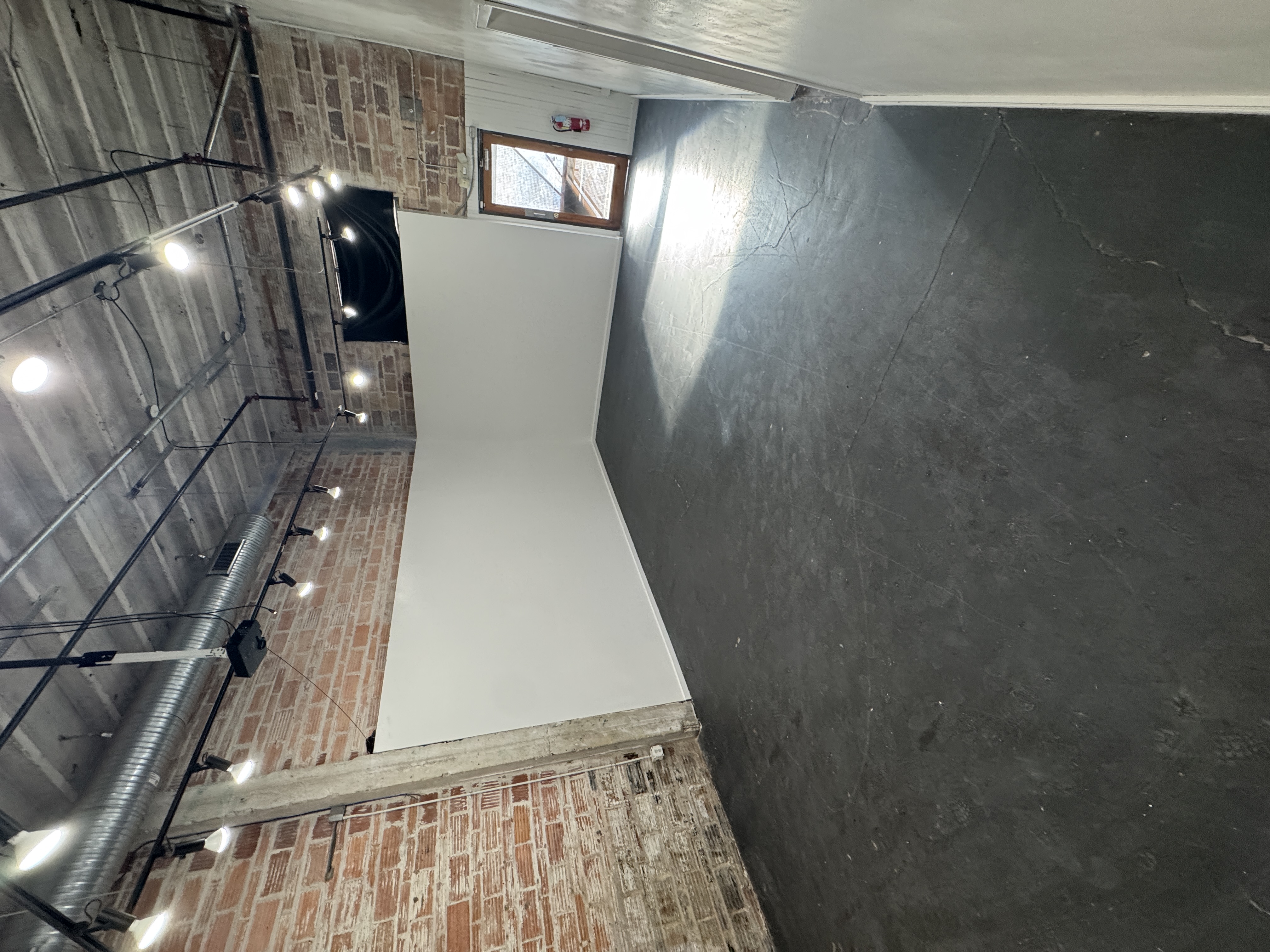 A corner of the empty main hall at 108 Blue Star with a high window