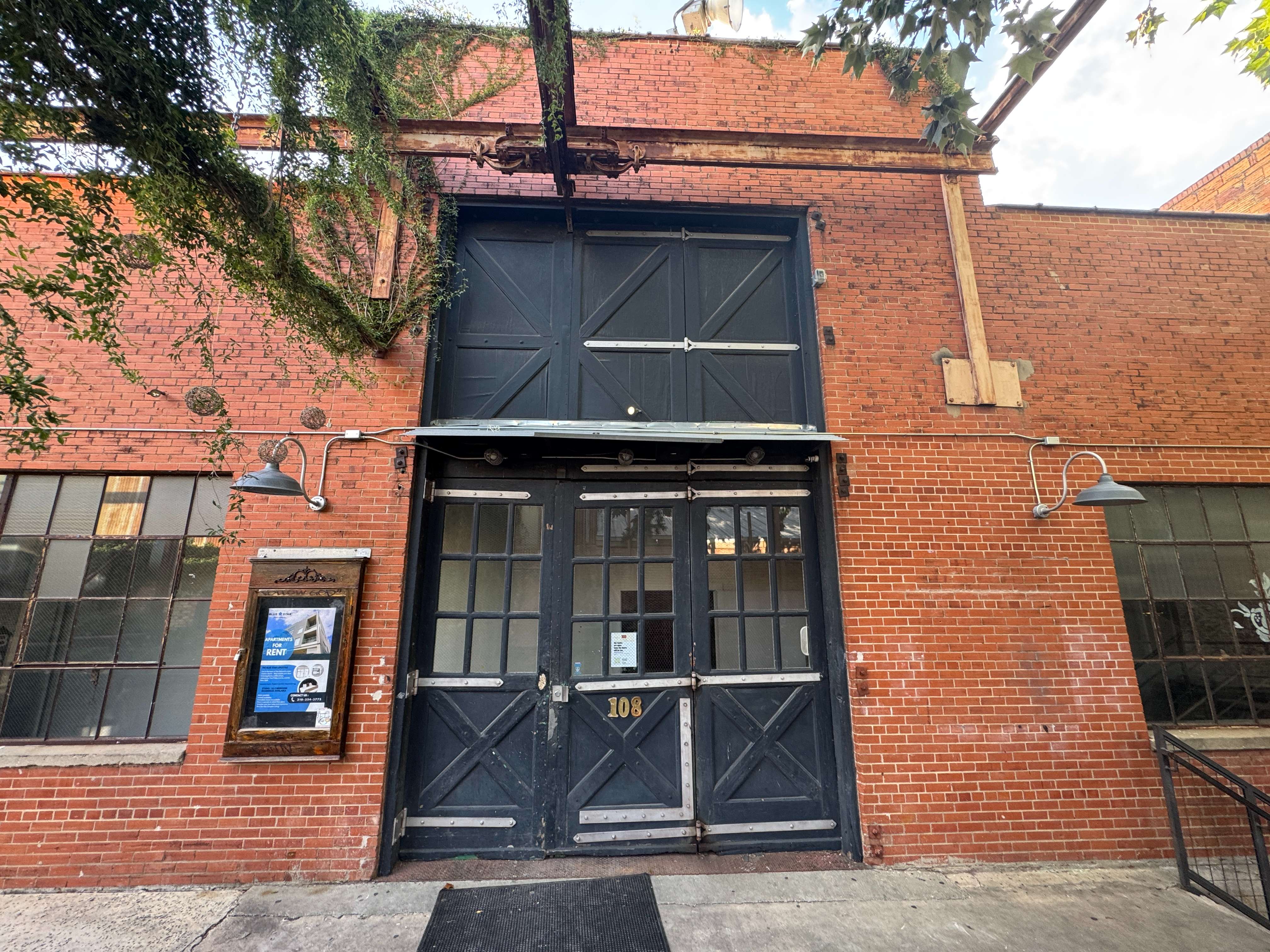 The 108 Blue Star entrance doors set into the brick facade