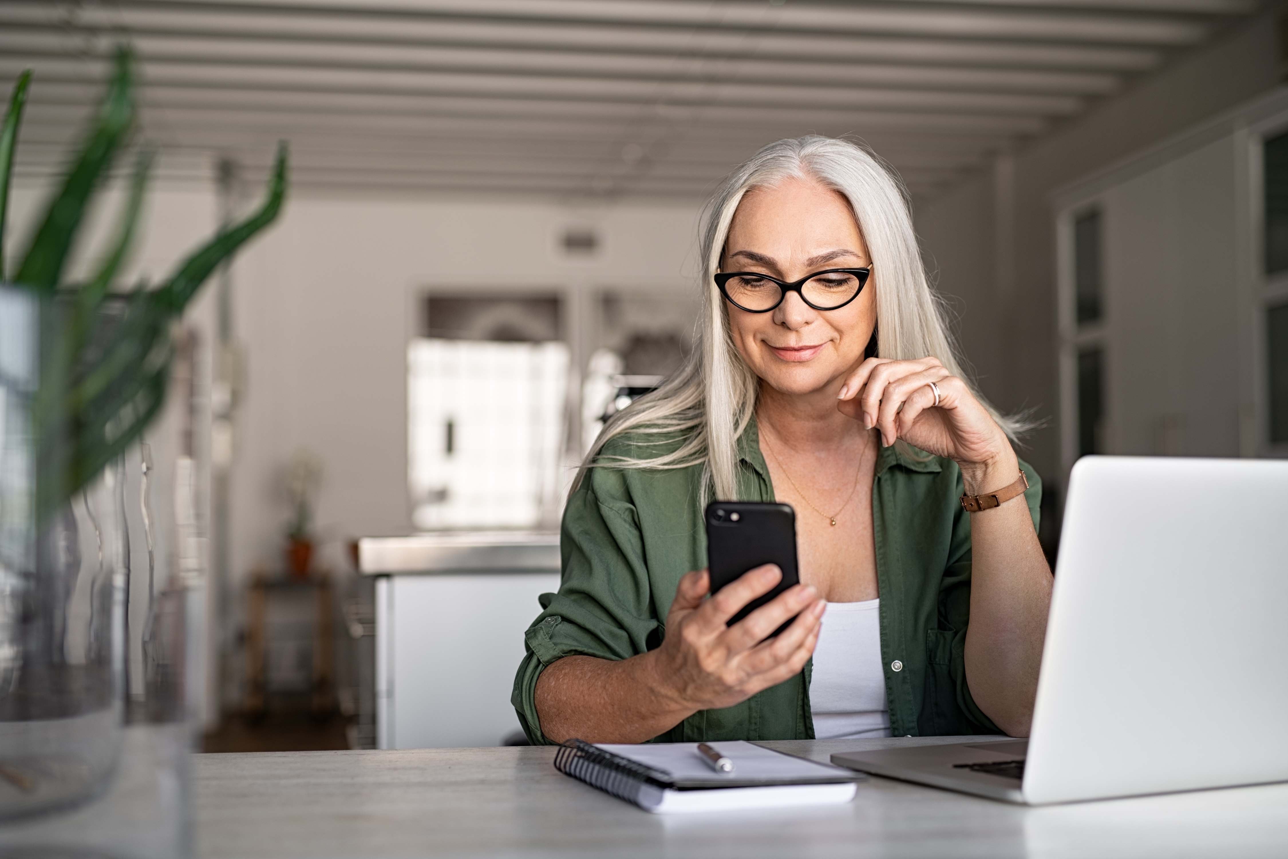 Senior woman sitting on her phone stock image