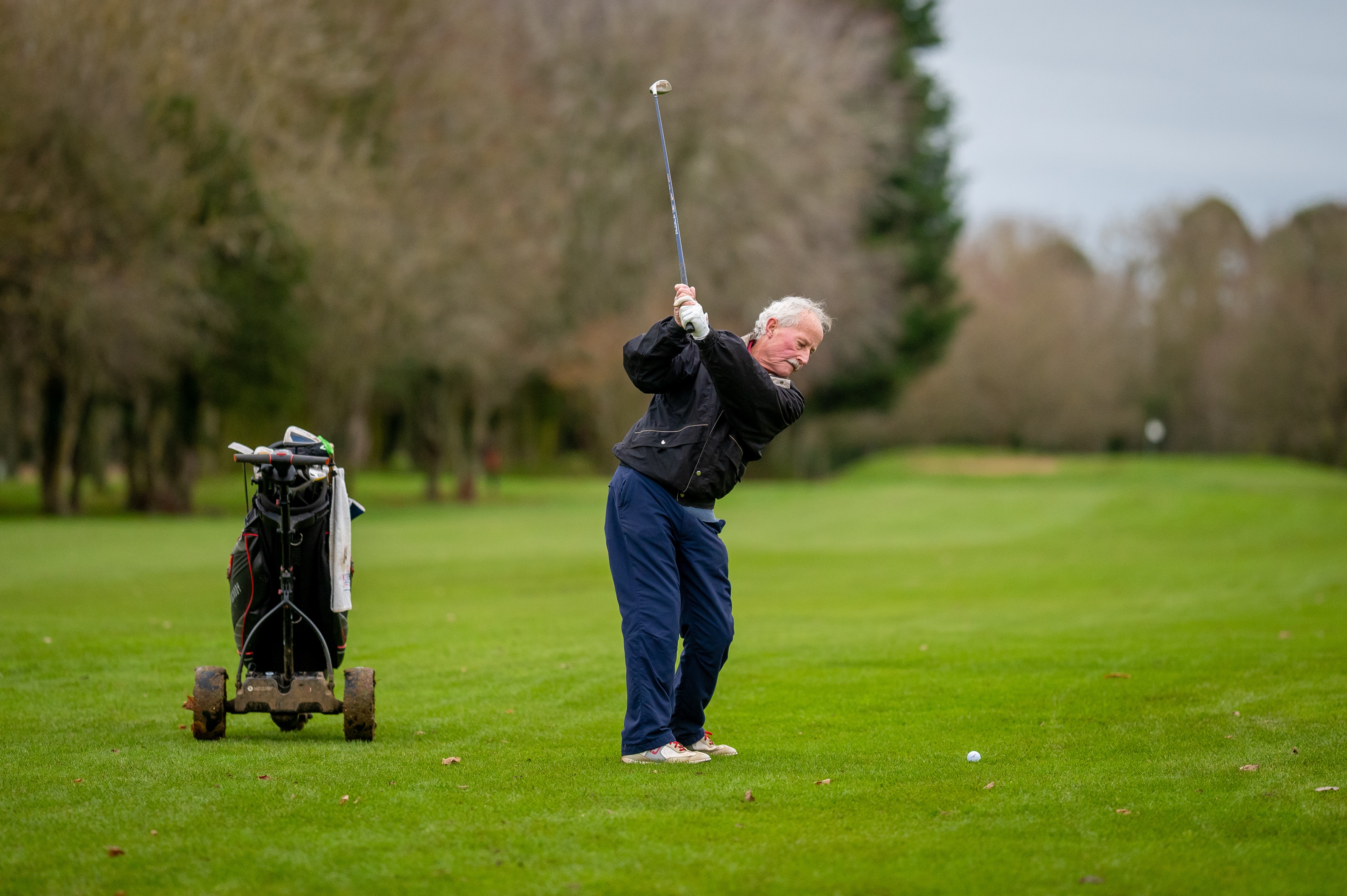 Senior man hitting a golf ball stock image