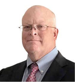 Portrait of a bald man wearing glasses, a black suit jacket, light blue shirt, and a pink patterned tie, against a white background.