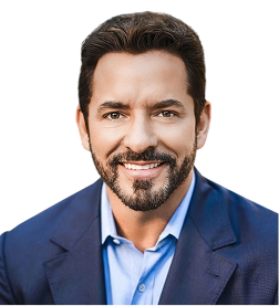 Smiling man with short dark hair and beard wearing a blue dress shirt and navy blazer against a white background.