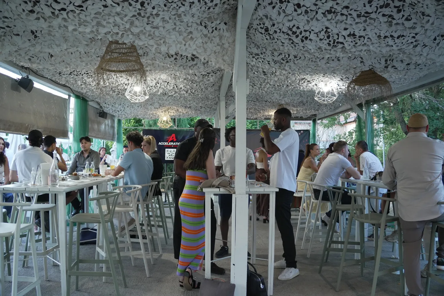Participants networking en soirée sous une tente décorée lors d'un afterwork Accélération.