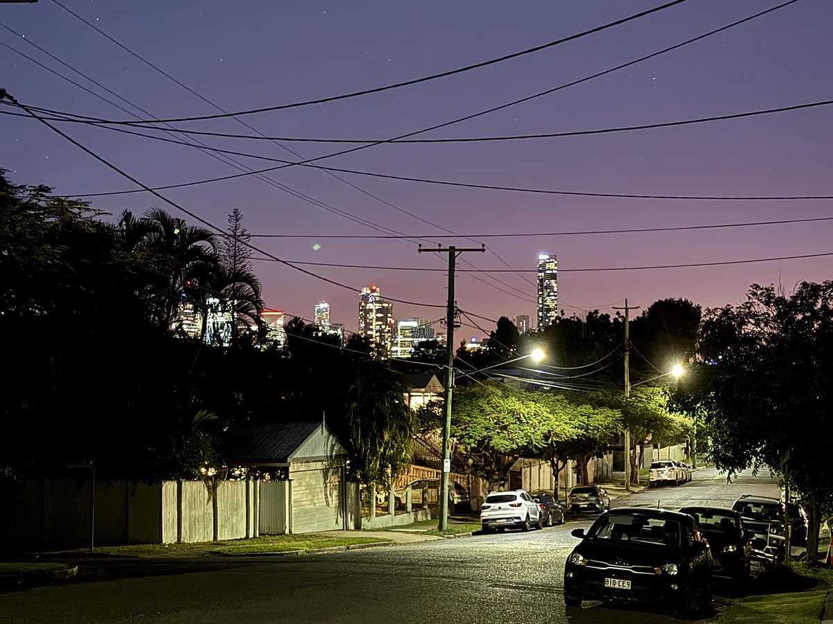A Hawthorne residential street at dusk with the Brisbane skyline beyond